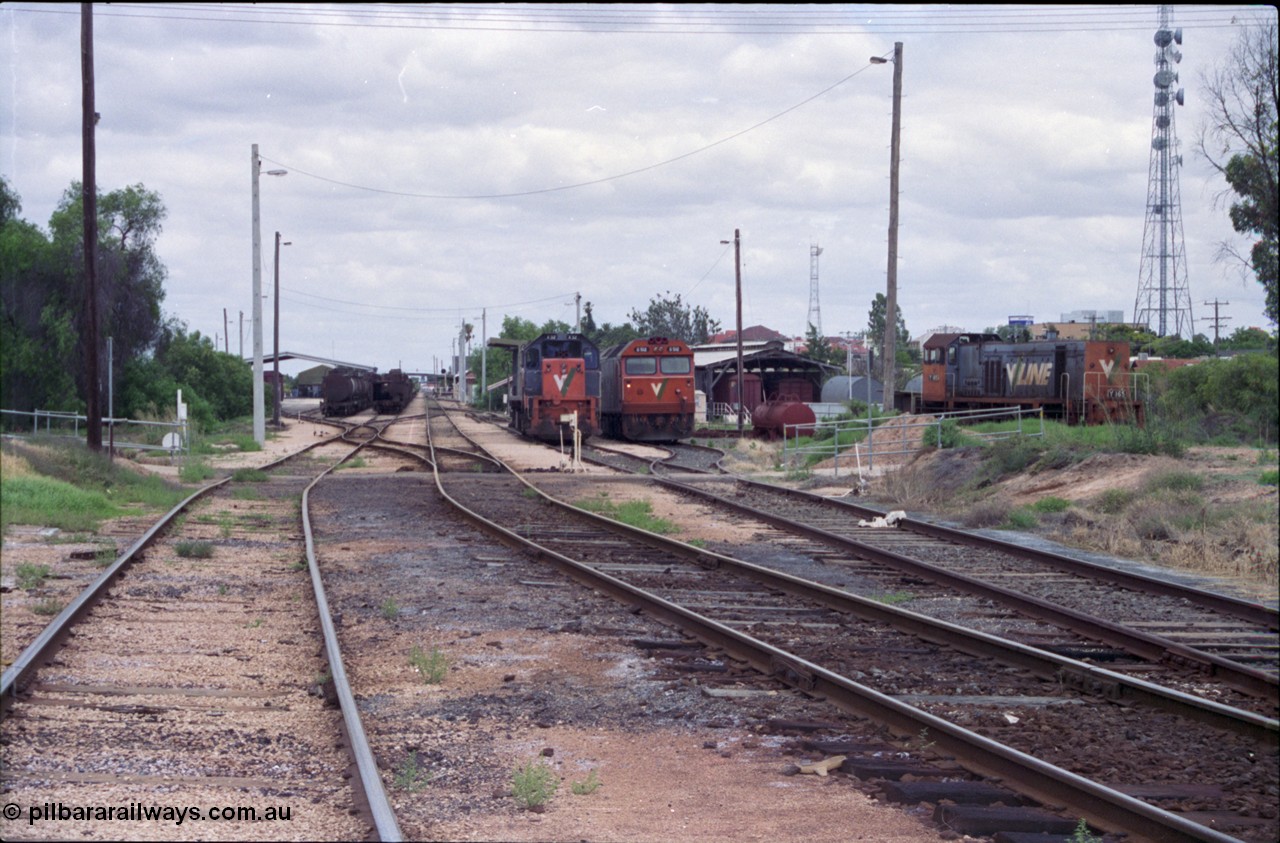 132-20
Mildura station yard overview, Freightgate in the background, oil pot rakes, mainline, loco depot, fuel point behind V/Line broad gauge X class X 32 Clyde Engineering EMD model G16C serial 66-485, G class G 512 Clyde Engineering EMD model JT26C-2SS serial 84-1240, carriage shed, Y class Y 165 Clyde Engineering EMD model G6B serial 68-585.
