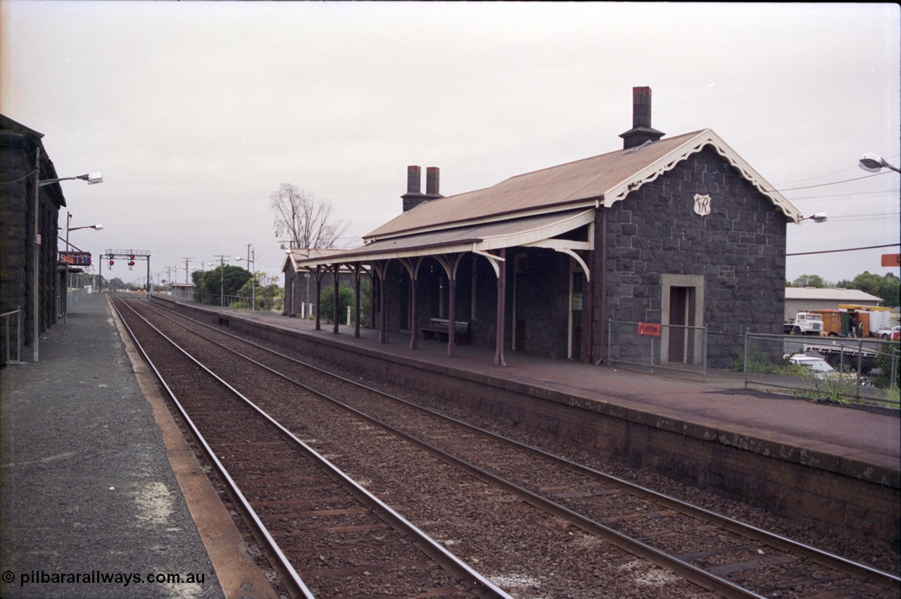 133-05
Little River, station building view, looking from up platform, bluestone buildings, Geelong line, signal gantry.
