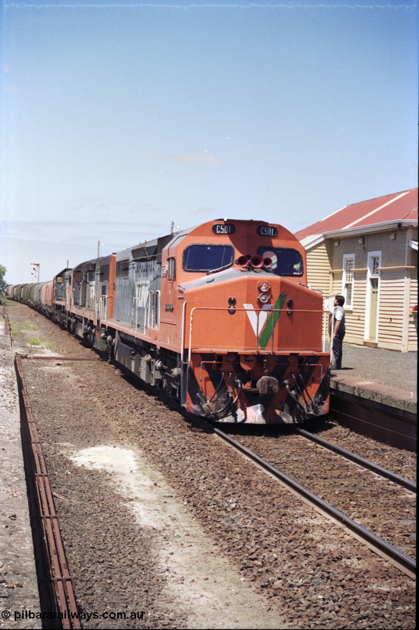 133-22
Gheringhap, V/Line broad gauge locos C class leader C 501 'George Brown' Clyde Engineering EMD model GT26C serial 76-824 leads C 506 serial 76-829 and X class X 45 'Edgar H Brownbill' Clyde Engineering EMD model G26C serial 75-792 with 9169 down Adelaide goods train, pausing to swap the electric staff for a train order, point rodding, signaller talking to crew.
Keywords: C-class;C501;Clyde-Engineering-Rosewater-SA;EMD;GT26C;76-824;