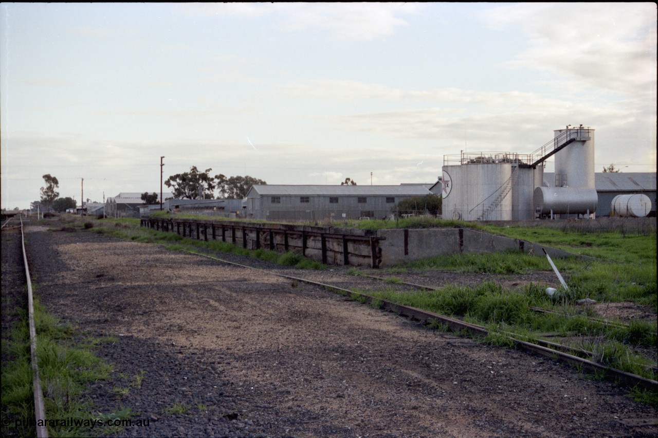 136-22
Deniliquin yard view, derelict loading ramp and platform, Caltex fuel facility behind, located opposite the Victorian Oats Pool shed, looking north towards Wood St.

