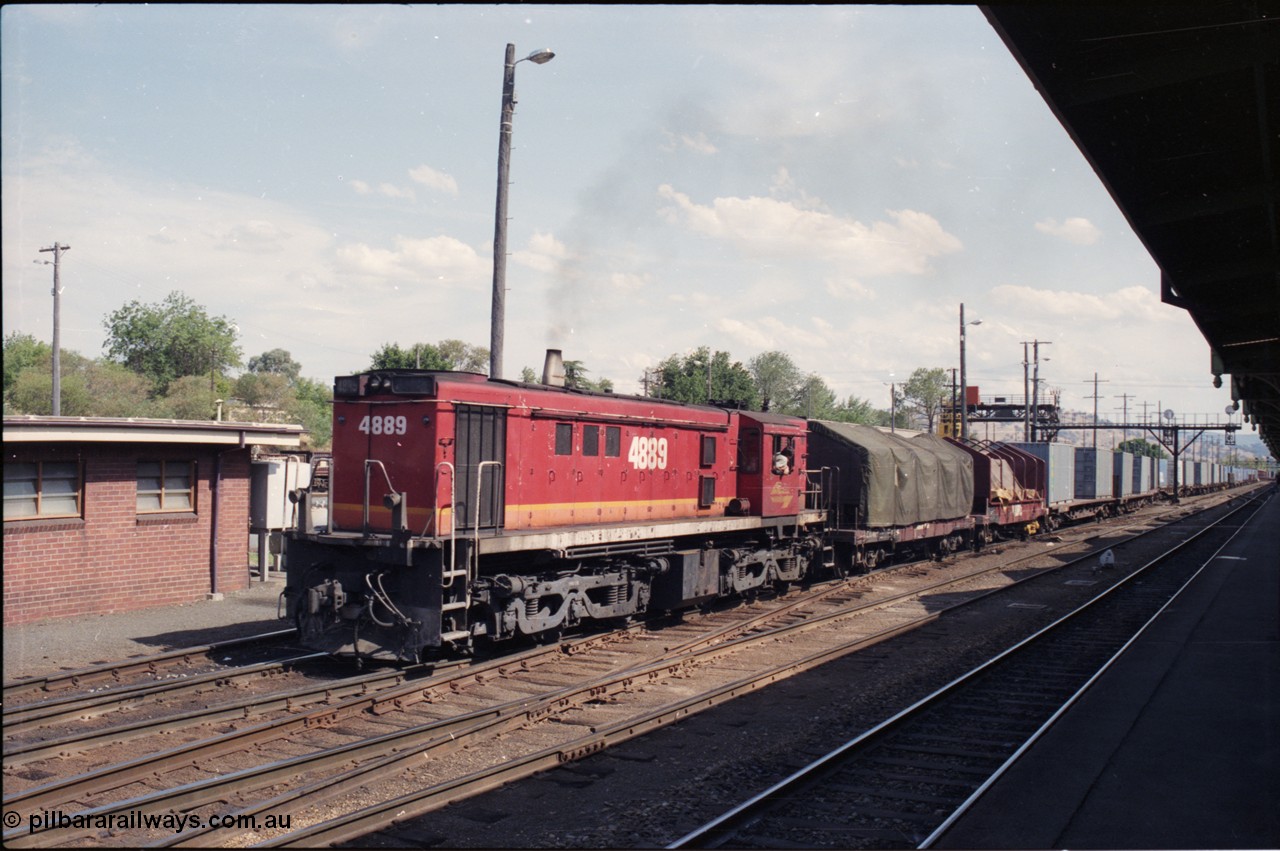 137-2-10
Albury station yard overview, standard gauge NSWSRA candy liveried 48 class 4889 AE Goodwin ALCo model DL531 serial G3420-4 shunts an arrival from Melbourne at Albury, two V/Line VCSX class bogie coil steel waggons lead the consist, the container waggons are being cut off.
Keywords: 48-class;4889;AE-Goodwin;ALCo;RSD-8;DL531;G3420-4;