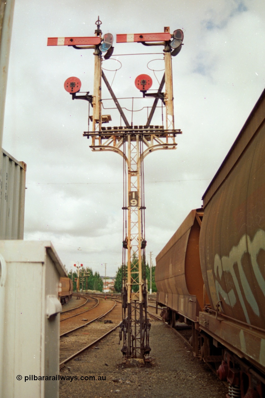 139-05
Ballarat yard, semaphore and disc signal Post 19 controlled from Ballarat Signal Box A or Ballarat Box, goods shed roads at left, goods platform roads at right, looking east. Right hand Arm Up Home No. 6 Road to the Up Passenger Line to Post 7, right hand Disc from No. 6 Road to 'D' towards Post 13, left hand Arm Up Home No. 7 Road to Up Passenger Line to Post 7 and left hand Disc from No. 7 Road to 'D' towards Post 13. The waggons at right are on No. 7 Road with the just visible grain waggons on No. 8 goods road with double disc Post 18.
