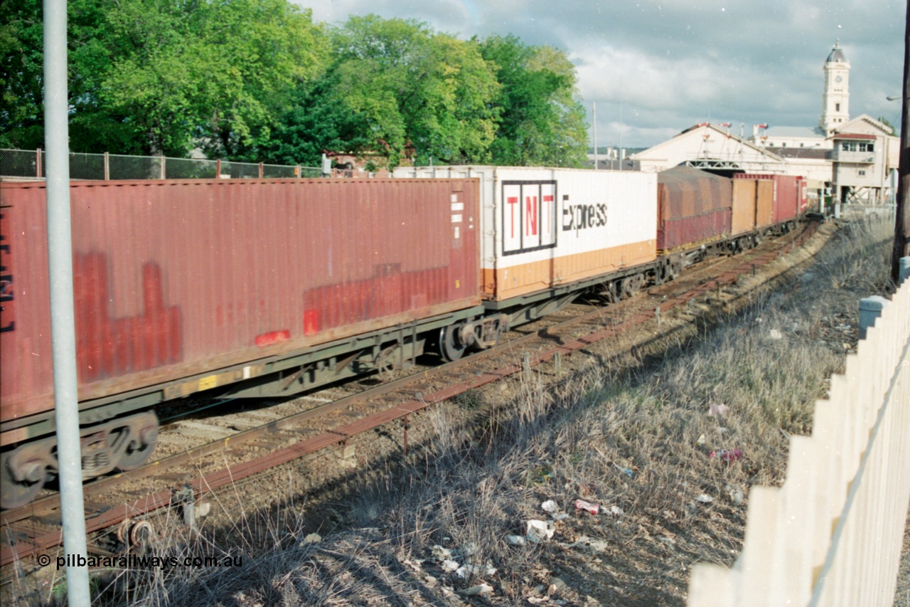 139-23
Ballarat, broad gauge Australian National AQKY type articulated 2-pack waggon with two 40 foot containers, part of a down Adelaide bound goods train, Ballarat station and Lydiard Street signal box in the background, point rodding and interlocking next to line.
Keywords: AQKY-type;