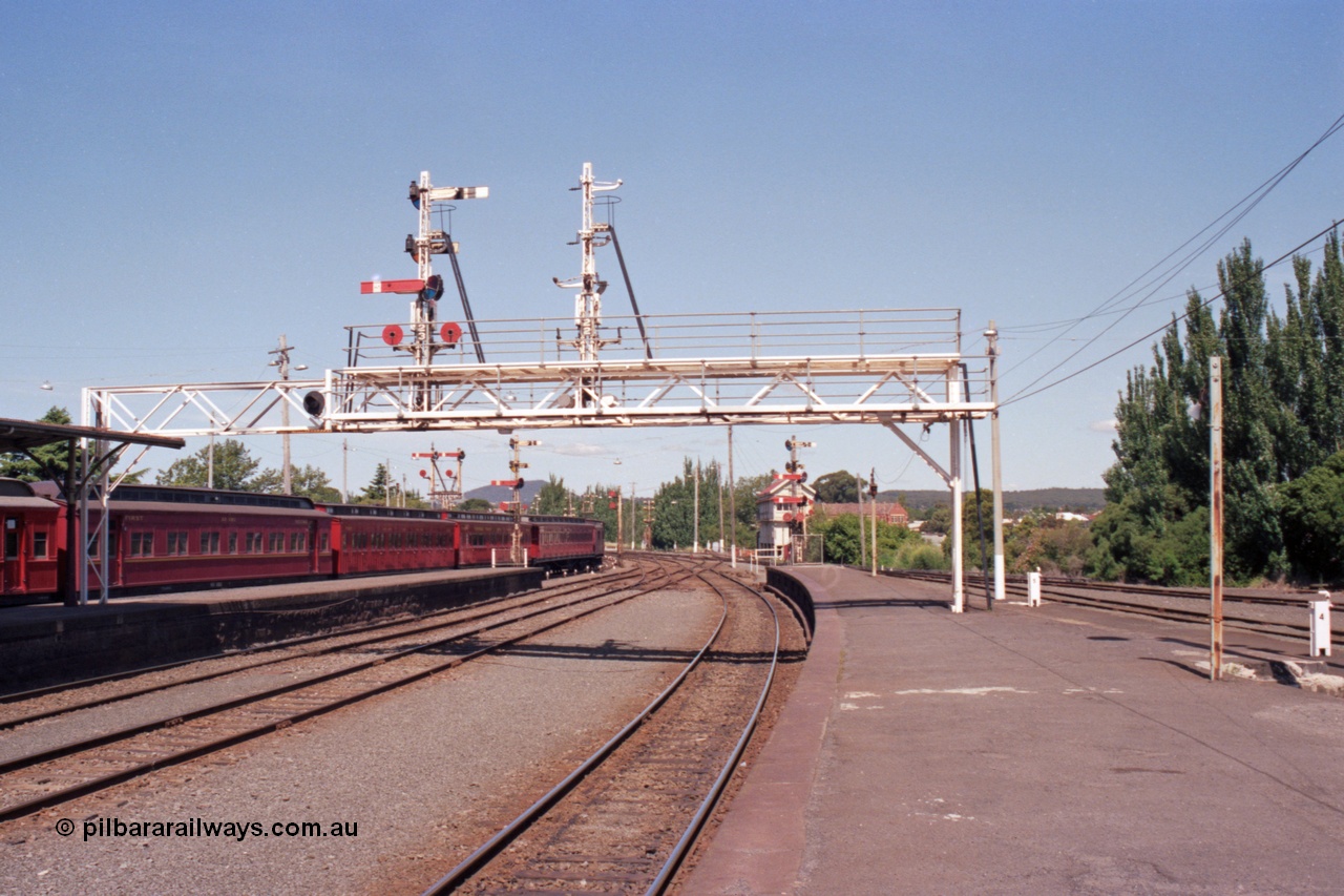 140-1-13
Ballarat station platform view from platform 1, E cars on No.5 Rd, looking east, A Box in the background, signal gantry semaphore signal post 23 is still in use, but as No.2 Rd has been removed signal post 22 has been stripped.
