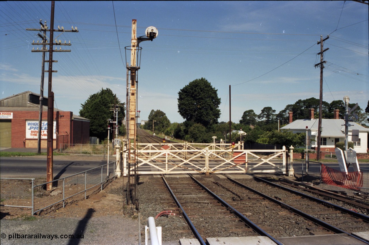 140-2-03
Ballarat, Linton Junction Signal Box, or Ballarat D, view of the interlocked gates looking towards Ballarat, the road is Gillies St, and with the impending boom barriers about to be commissioned, the gates days are numbered, the disc signal post 21 is the up line to Timken's Sidings signal.

