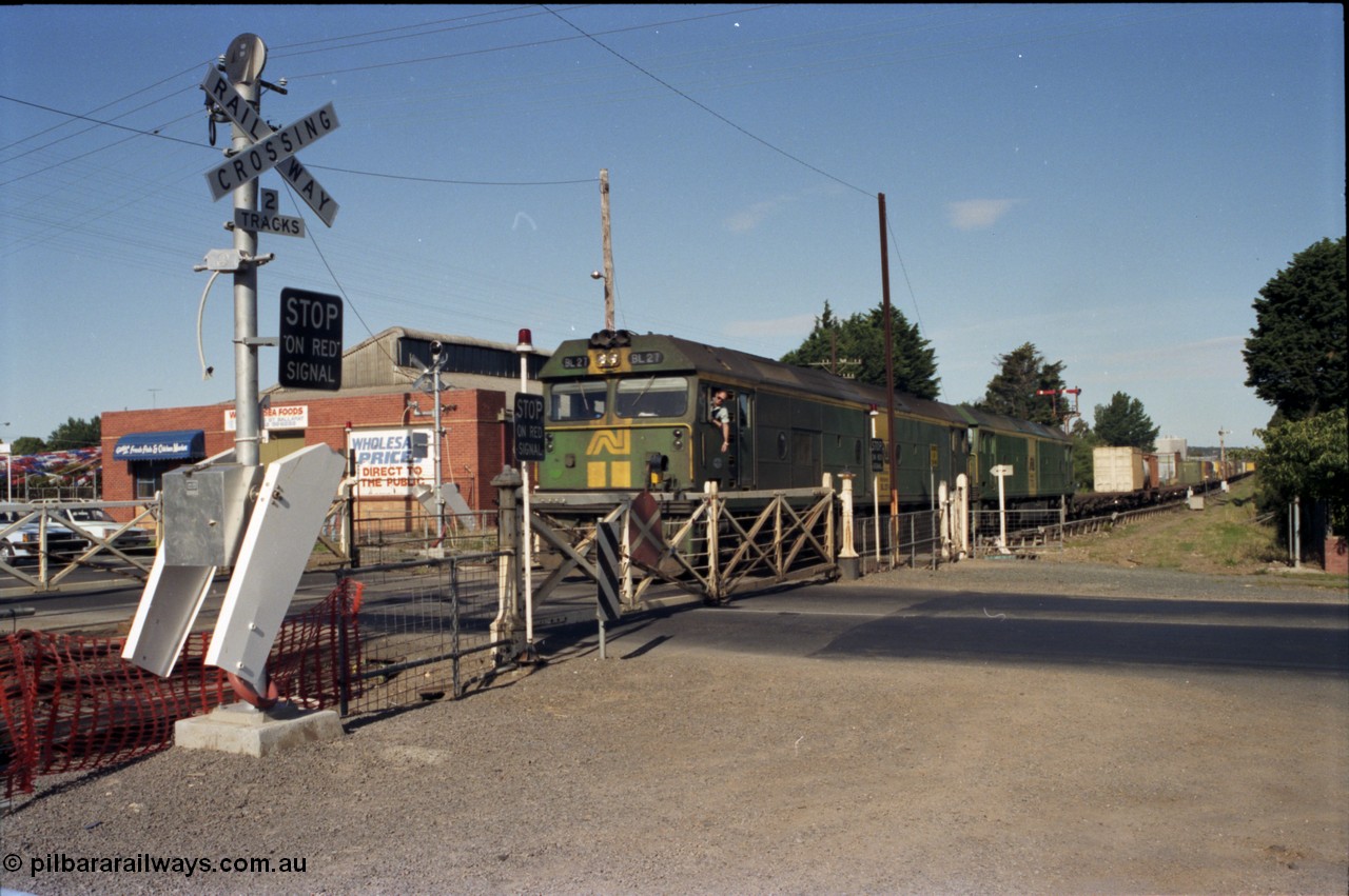 140-2-07
Ballarat, Linton Junction Signal Box, or Ballarat D, looking towards Ballarat, Australian National BL class BL 27 Clyde Engineering EMD model JT26C-2SS serial 83-1011 leads another BL class with an Adelaide bound down goods train at Linton Junction as the driver leans out the cab window to collect the electric staff for the section Linton Junction - Trawalla, crossing Gillies Street through the interlocked swing gates. The boom barrier installation will render these interlocked gate obsolete in a few weeks time.
Keywords: BL-class;BL27;Clyde-Engineering-Rosewater-SA;EMD;JT26C-2SS;83-1011;