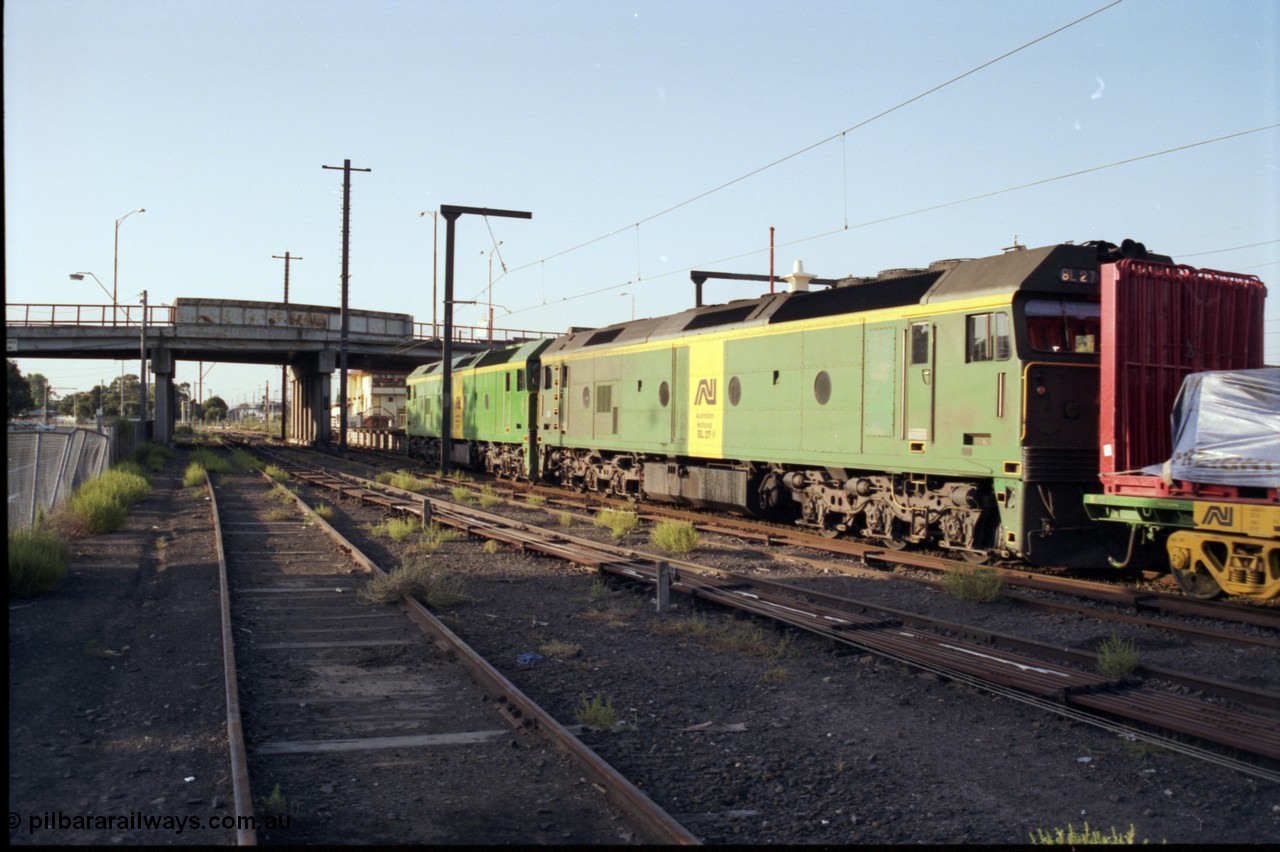 141-1-12
Sunshine, broad gauge Australian National BL class units BL 28 Clyde Engineering EMD model JT26C-2SS serial 83-1012 and BL 27 serial 83-1011 lead the second of the afternoon procession of down Adelaide bound goods trains out of Melbourne along platform No.3, point rodding, station platform, signal box, Hampshire Road overbridge, taken from former goods yard, trailing view.
Keywords: BL-class;BL27;Clyde-Engineering-Rosewater-SA;EMD;JT26C-2SS;83-1011;