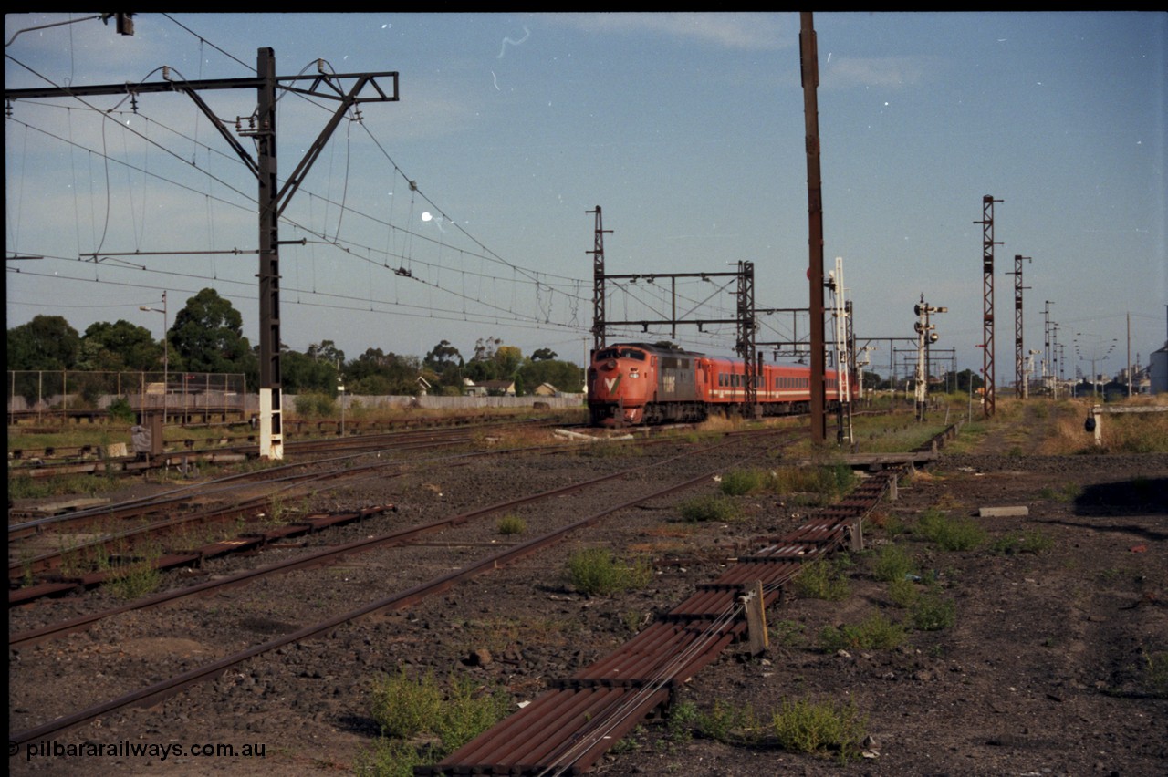 141-2-07
Sunshine, broad gauge V/Line A class A 78 Clyde Engineering EMD model AAT22C-2R serial 84-1185 rebuilt from B 78 Clyde Engineering EMD model ML2 serial ML2-19 with an N set and D van on a down Ballarat passenger train head onto No.3 Rd, point rodding.
Keywords: A-class;A78;Clyde-Engineering-Rosewater-SA;EMD;AAT22C-2R;84-1185;rebuild;bulldog;