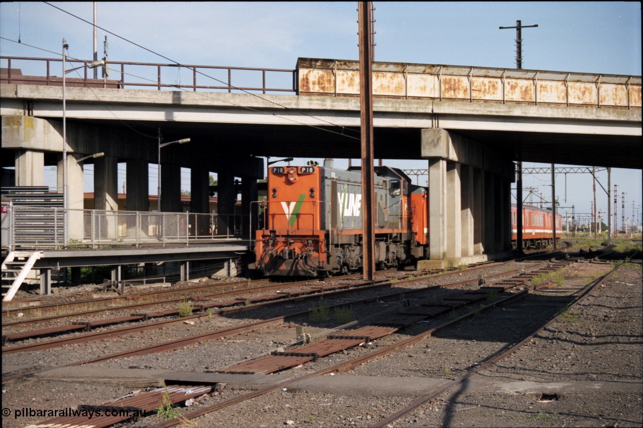 141-2-10
Sunshine, broad gauge V/Line P class P 18 Clyde Engineering EMD model G18HBR serial 84-1211 rebuilt from T 339 Clyde Engineering EMD model G8B serial 56-115 leads an H set underneath the Hampshire Road overbridge with a down Bacchus Marsh passenger train at platform No.3, taken from the remains of Sunshine goods yard, point rodding.
Keywords: P-class;P18;Clyde-Engineering-Somerton-Victoria;EMD;G18HBR;84-1211;rebuild;