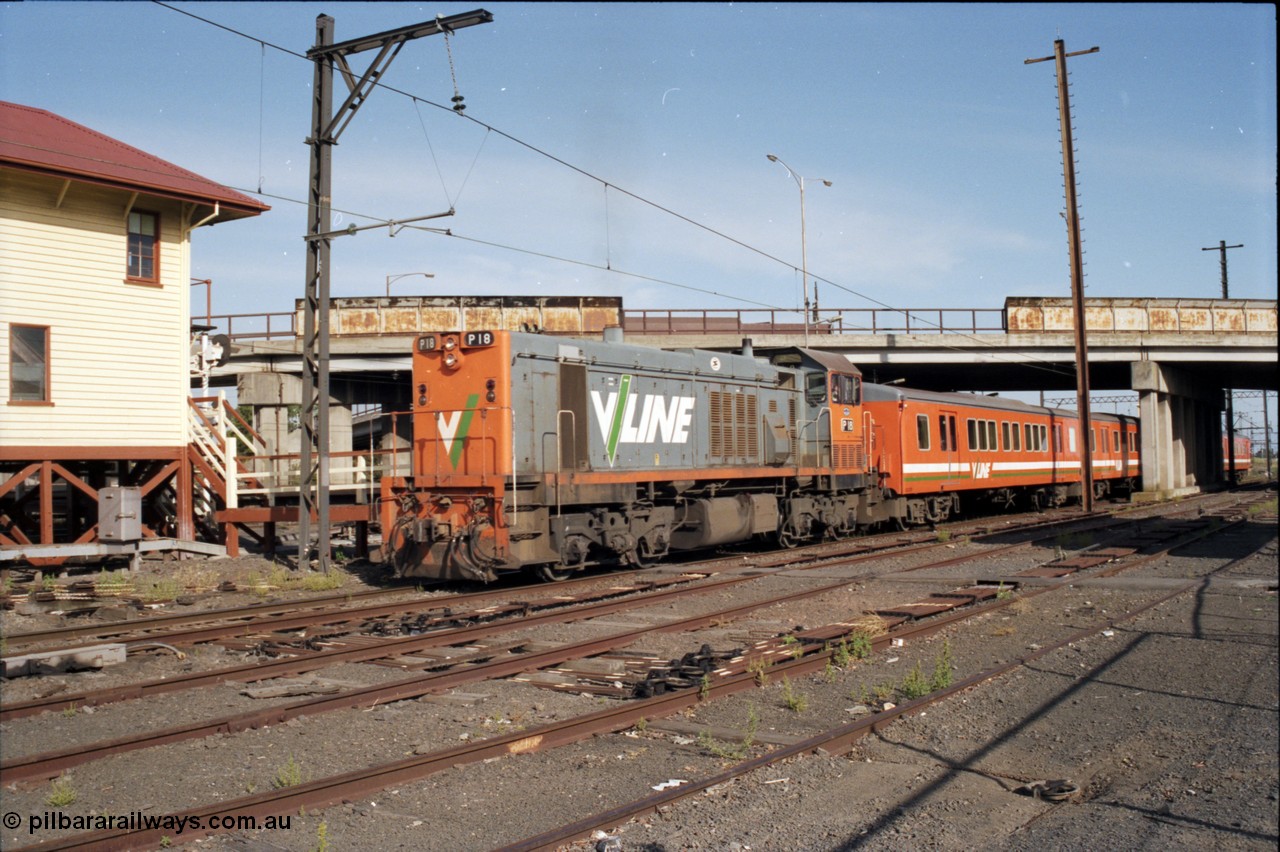 141-2-11
Sunshine, broad gauge V/Line P class P 18 Clyde Engineering EMD model G18HBR serial 84-1211 rebuilt from T 339 Clyde Engineering EMD model G8B serial 56-115 leads an H set underneath the Hampshire Road overbridge with a down Bacchus Marsh passenger train departing platform No.3 and heading west passing the back of the signal box, point rodding and signal wires, interlocking, former goods yard.
Keywords: P-class;P18;Clyde-Engineering-Somerton-Victoria;EMD;G18HBR;84-1211;rebuild;
