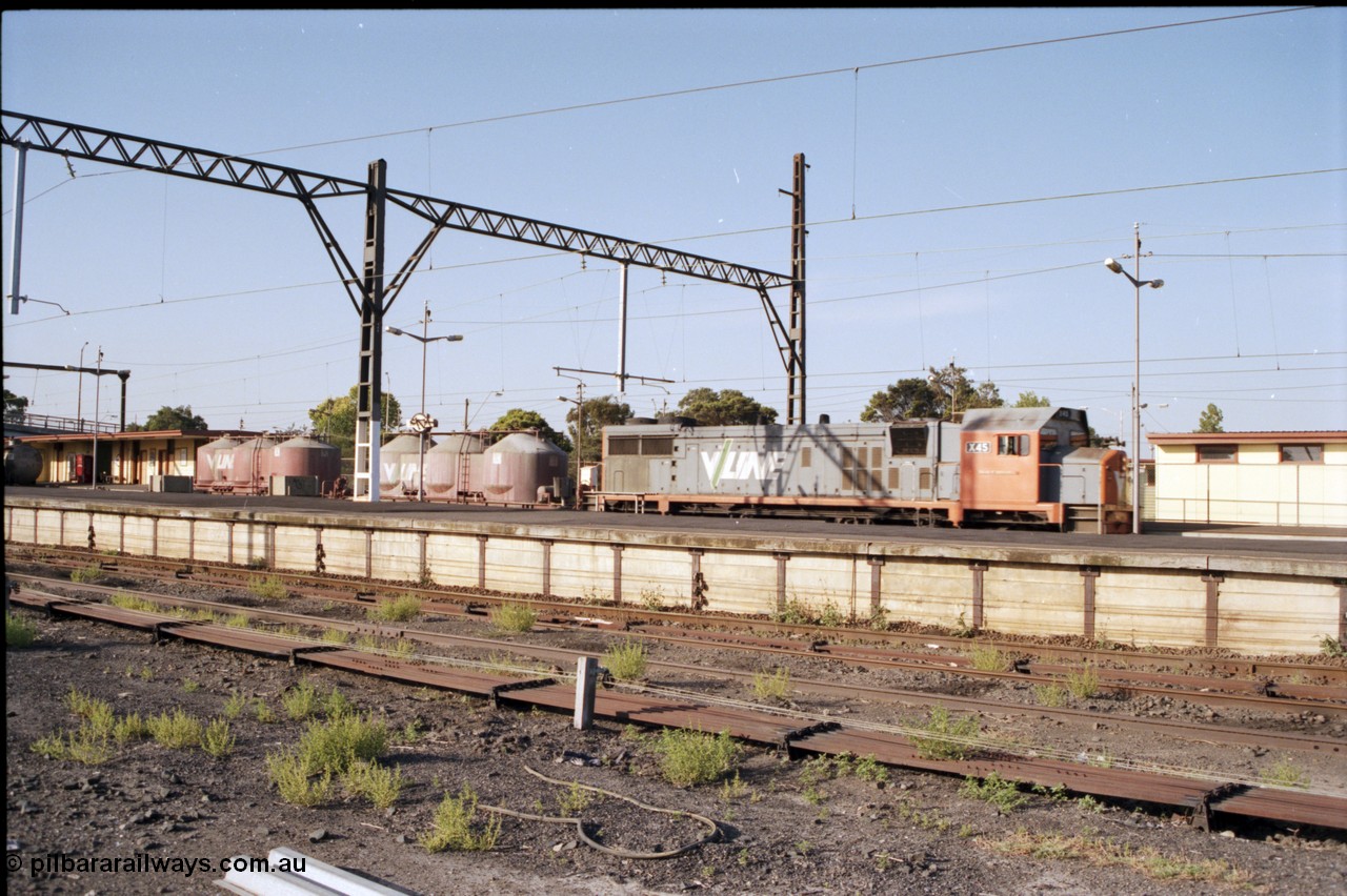141-2-18
Sunshine, broad gauge V/Line X class X 45 'Edgar H Brownbill' Clyde Engineering EMD model G26C serial 75-792 leads an up Bendigo goods train through platform No.1 to Tottenham Yard, platform No.3 and point rodding in foreground.
Keywords: X-class;X45;Clyde-Engineering-Rosewater-SA;EMD;G26C;75-792;