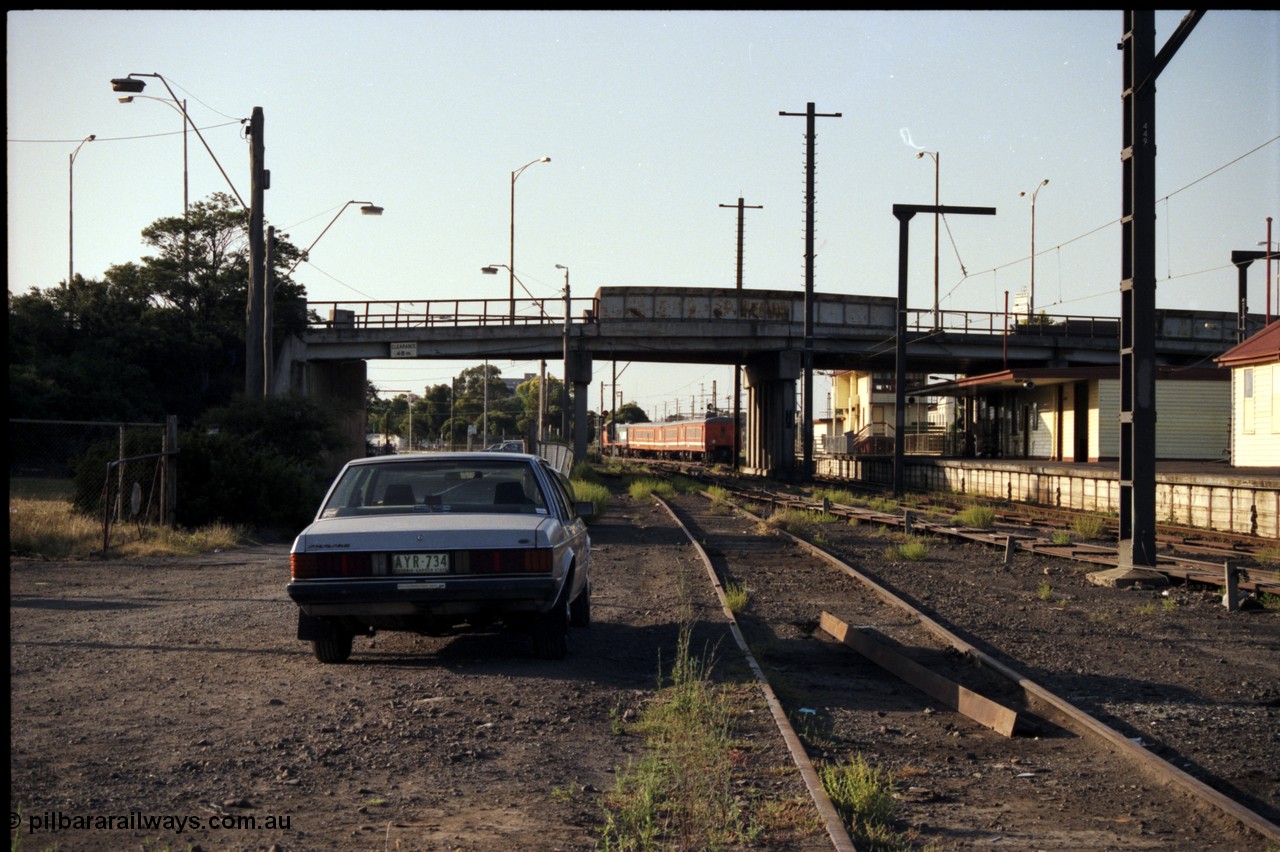 141-2-24
Sunshine, view looking north, Hampshire Road overbridge, V/Line broad gauge P class P 15 Clyde Engineering EMD model G18HBR serial 84-1209 rebuilt from T 344 Clyde Engineering EMD model G8B serial 56-127 with down Bacchus Marsh passenger train, signal box, station platform No.3 and station building visible, the track is No.5 Road, point rodding, trailing view.
