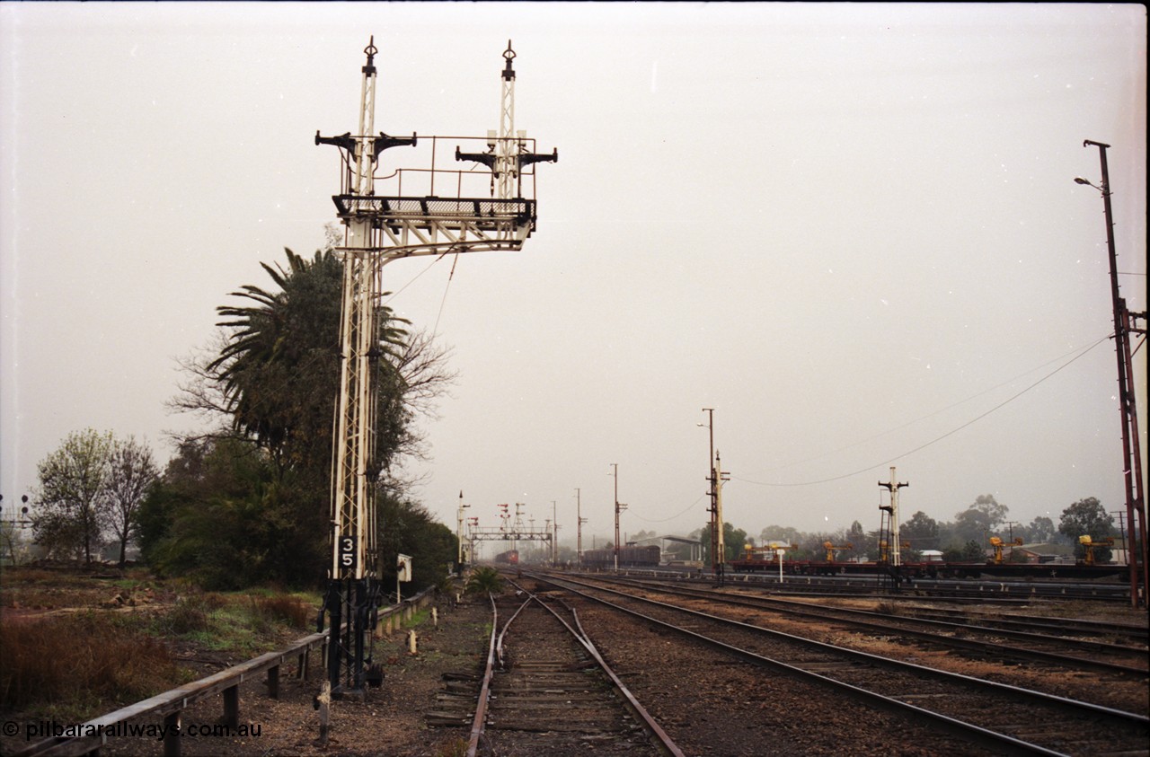 142-1-21
Benalla station yard view from Siding Z and oil siding points, signal post 35 stripped, points and crossover from Siding Z to mainline removed, stripped signal disc posts 32 and 29 on the right.
