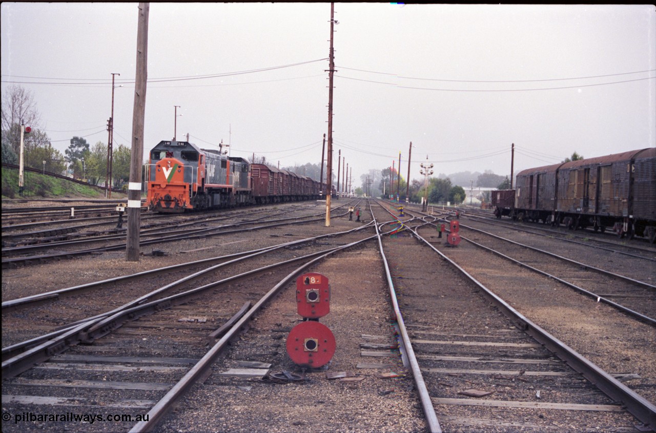 142-1-23
Benalla station yard overview looking south, dwarf disc signals 18 and 17 facing camera, 9303 stabled Wodonga goods with V/Line broad gauge locos X class X 48 Clyde Engineering EMD model G26C serial 75-795 and T class T 408 Clyde Engineering EMD model G18B serial 68-624, taken from Siding K, Dock D beside train, then 4, 5 and 6 Roads, dwarf discs facing away are 15, 13 and 10, disc signal post 12, NSW louvre vans at right.
Keywords: X-class;X48;Clyde-Engineering-Rosewater-SA;EMD;G26C;75-795;