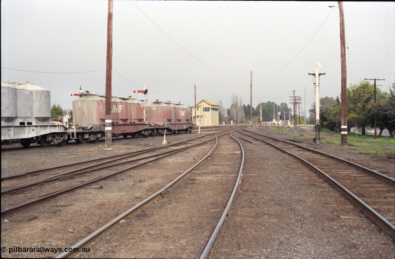 142-1-35
Benalla yard overview looking south from goods yard, No. 4, 5, and 6 Roads end with goods yard road on the right, remains of Siding B can be seen beyond stripped disc signal post 9, semaphore signal posts 7 and 7B are visible behind the VPCX class waggons, Benalla A signal box and disc signal 

