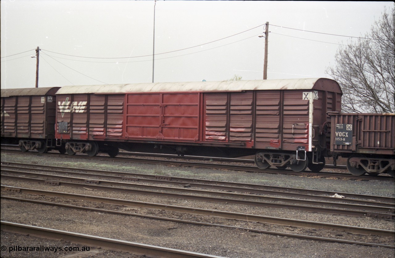 142-1-37
Benalla yard, V/Line broad gauge VLEX type bogie louvre van VLEX 1037 with fresh painted door, stabled Wodonga goods train 9303. VLEX 1037 was built in July 1976 at Ballarat North Workshops as a VSX type, recoded to VLEY in October 1979, then VLEX in December 1982.
Keywords: VLEX-type;VLEX1037;Victorian-Railways-Ballarat-Nth-WS;VSX-type;