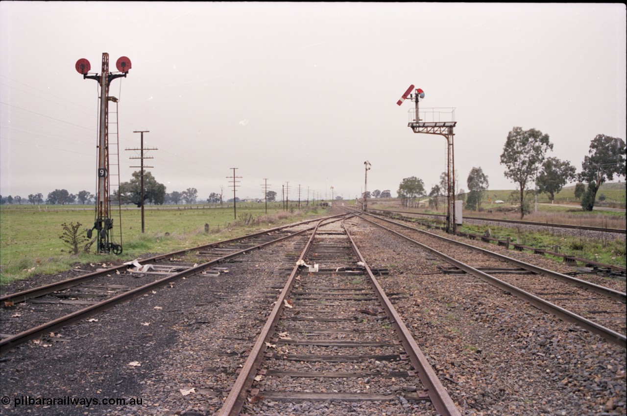 142-2-07
Barnawartha, yard overview looking north, disc signal post 9, semaphore signal posts 10, 11 and 18? pulled off indicating signal box switched out, derails on siding tracks, standard gauge on the far right.

