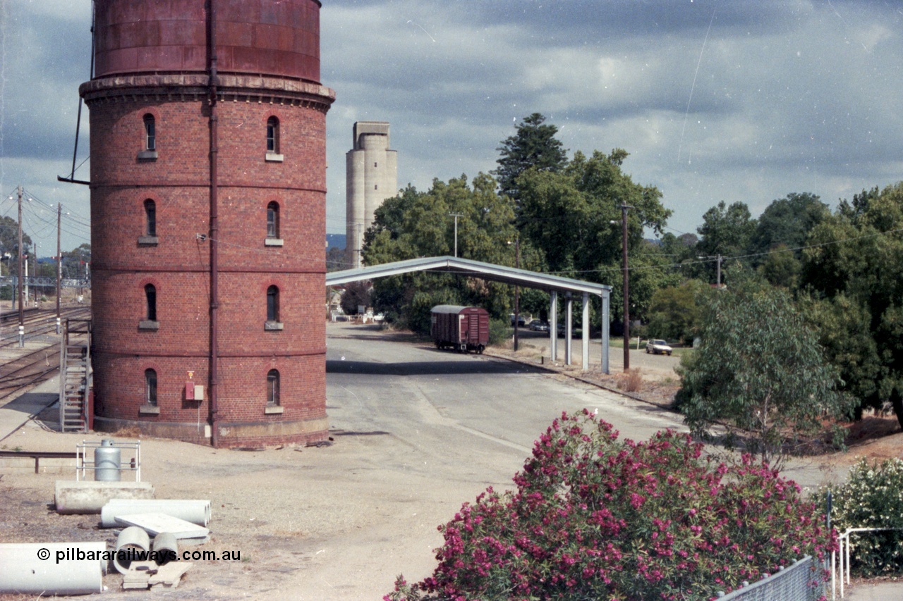 143-02
Wangaratta, goods area, water tower and Freight Gate canopy with V/Line bogie louvre van and silos in the distance, taken from footbridge.
