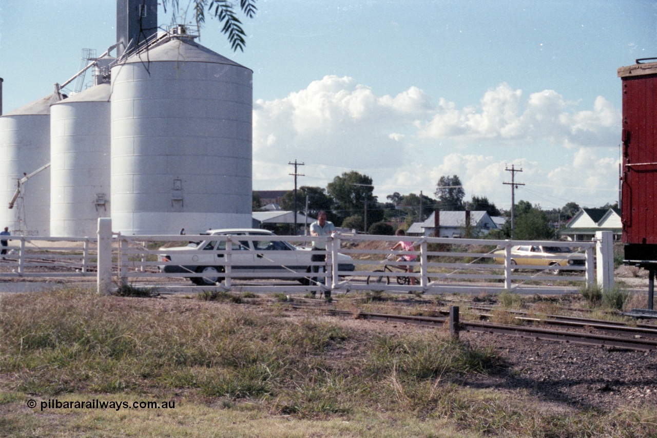143-37
Rutherglen, the non-interlocked hand operated swing gates on Howlong St are closed following the departure of the up 'Stringybark Express' mixed special, the trailing edge of ZL 2 just visible, Ascom silos in the background.

