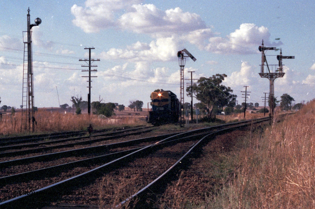 144-03
Springhurst yard view looking north, up Wahgunyah 'Stringybark Express' mixed special hauled by broad gauge VR liveried Y class Y 133 Clyde Engineering EMD model G6B serial 65-399 on the Wahgunyah line pulls forward into Springhurst at semaphore signal Post 6, the Up Home Wahgunyah Line to No. 2 Rd to Post 3, the other signals are disc Post 5 from Siding A to No. 2, 3, 4 or 5 Roads and on the right is semaphore signal Post 8 the Up Home Wodonga Line, the embankment at the far right is the standard gauge flyover.
Keywords: Y-class;Y133;Clyde-Engineering-Granville-NSW;EMD;G6B;65-399;