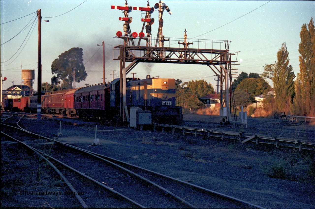 144-14
Wangaratta station yard view, VR liveried broad gauge Y class Y 133 Clyde Engineering EMD model G6B serial 65-399 leads the Wahgunyah 'Stringybark Express' mixed special south bound for Benalla under the signal gantry with semaphore signal Post 9 arm Up Home Signal 'A' to Main Line to Post 1 pulled off for the move.
Keywords: Y-class;Y133;Clyde-Engineering-Granville-NSW;EMD;G6B;65-399;
