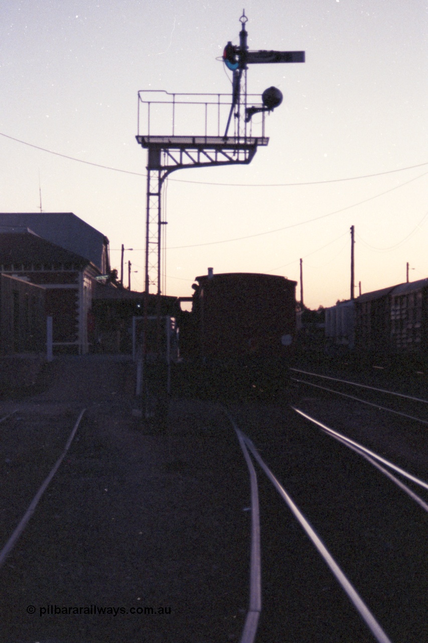144-19
Benalla station platform, silhouette image of ZL type six wheel guards van ZL 2 on the up Wahgunyah 'Stringybark Express' mixed and semaphore signal Post 11.
