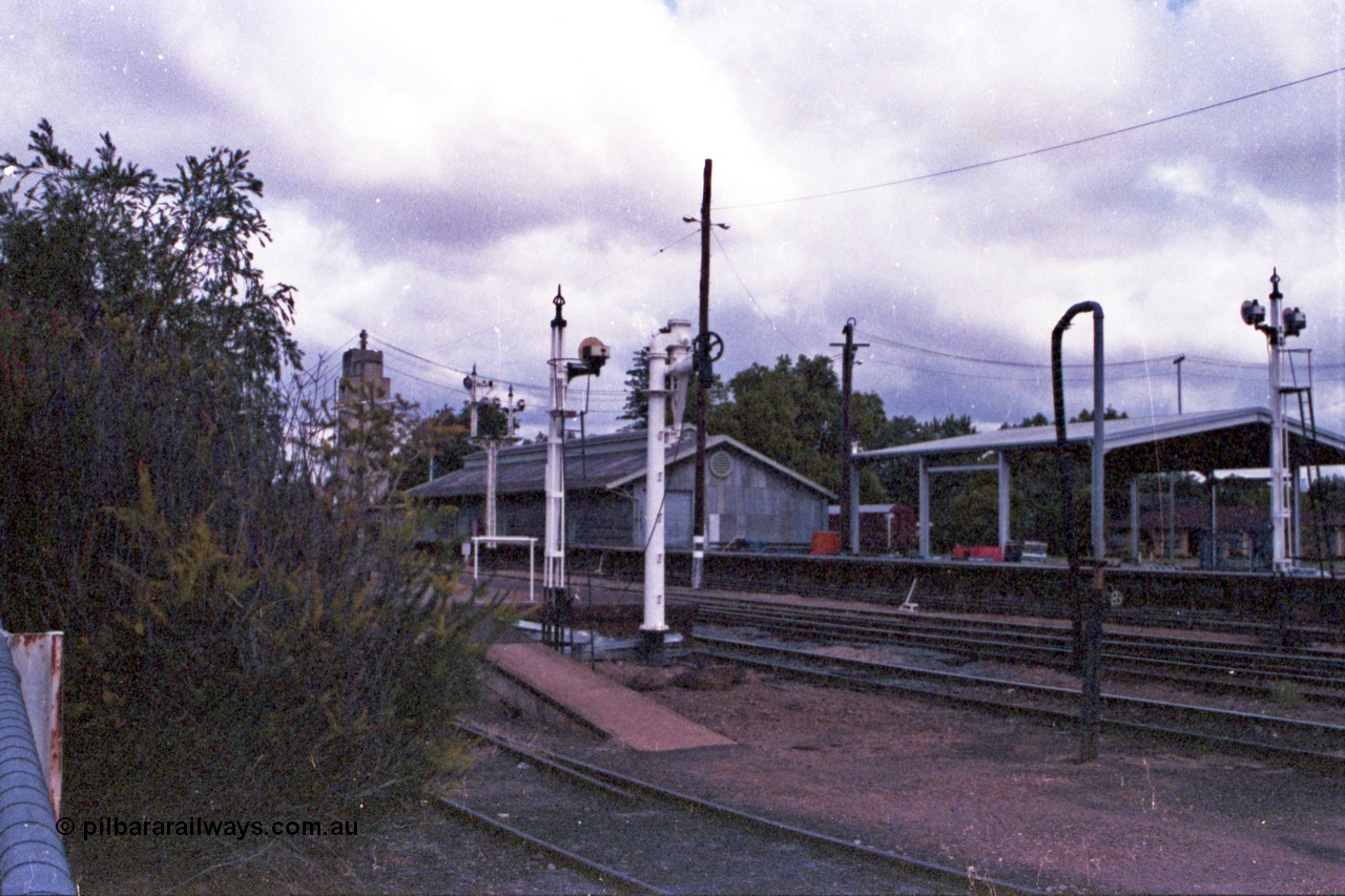 148-03
Wangaratta, view of disc signal post 18 for Siding A to Main Line, old and new water standpipes and twin disc signal post 19, goods shed and platform with 'Freight Gate' canopy in the background.

