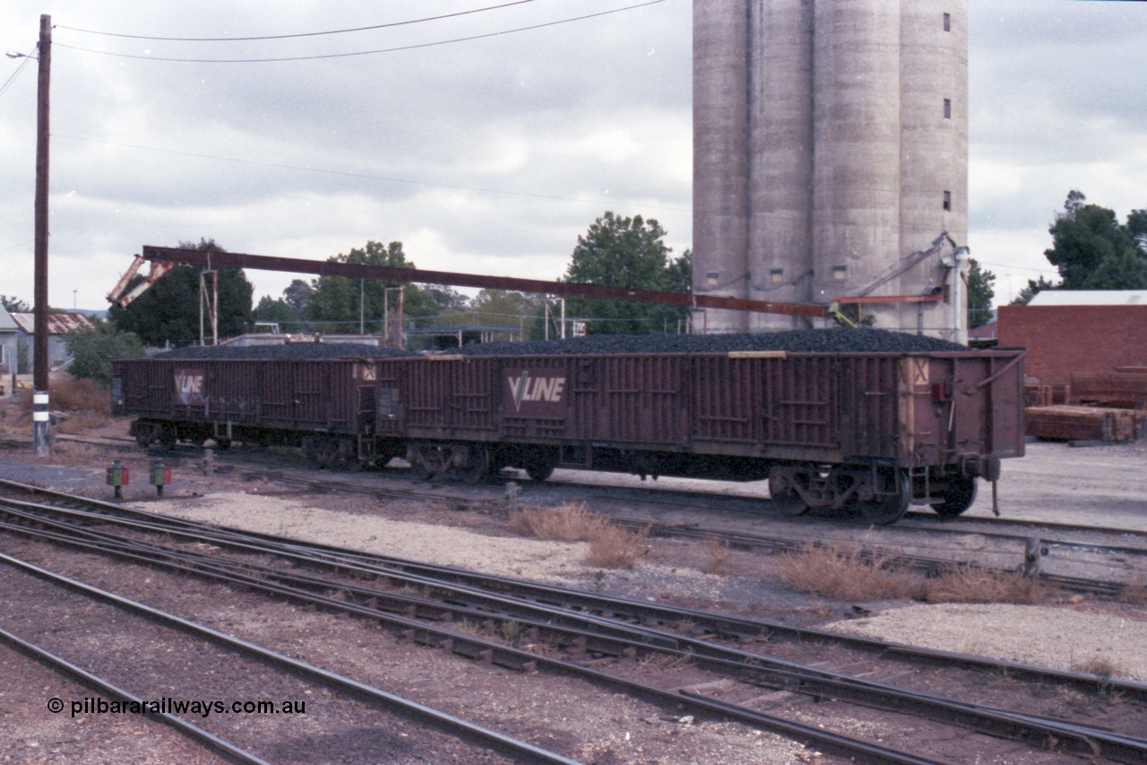 148-14
Wangaratta, V/Line VOCX bogie open waggons, VOCX 122, loaded with briquettes on the old works platform road, looking towards Sidings E, silos in the background. VOCX 122 was built by Ballarat North Workshops May 1968 as ELX type ELX 122. In 1979 re-coded to VOCX. In 1994 re-coded to ROBX.
Keywords: VOCX-type;VOCX122;Victorian-Railways-Ballarat-Nth-WS;ELX-type