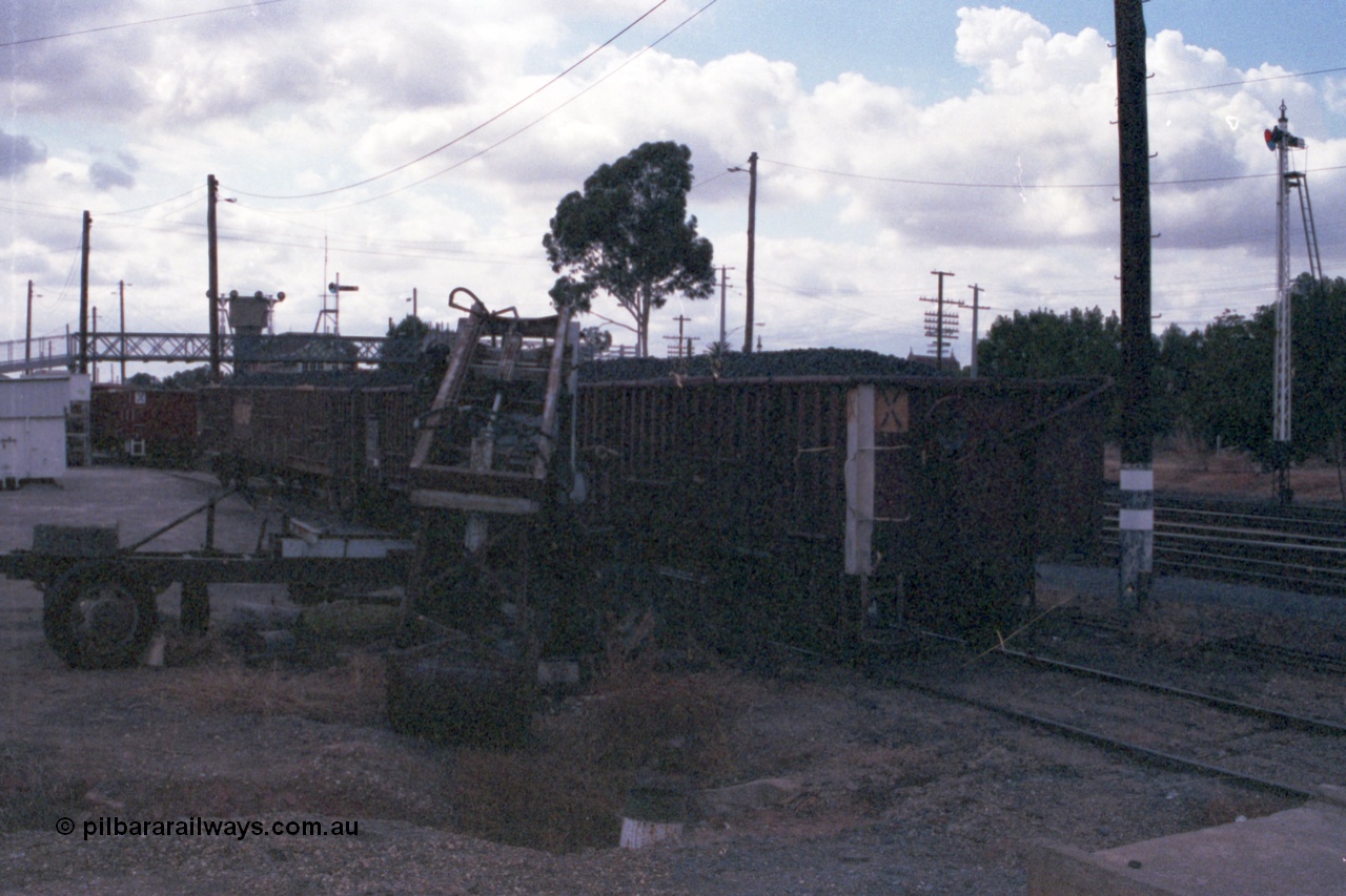 148-23
Wangaratta, V/Line VOCX type bogie open waggons loaded with briquettes, rudimentary unloading contraption, looking north, image is very dark.
