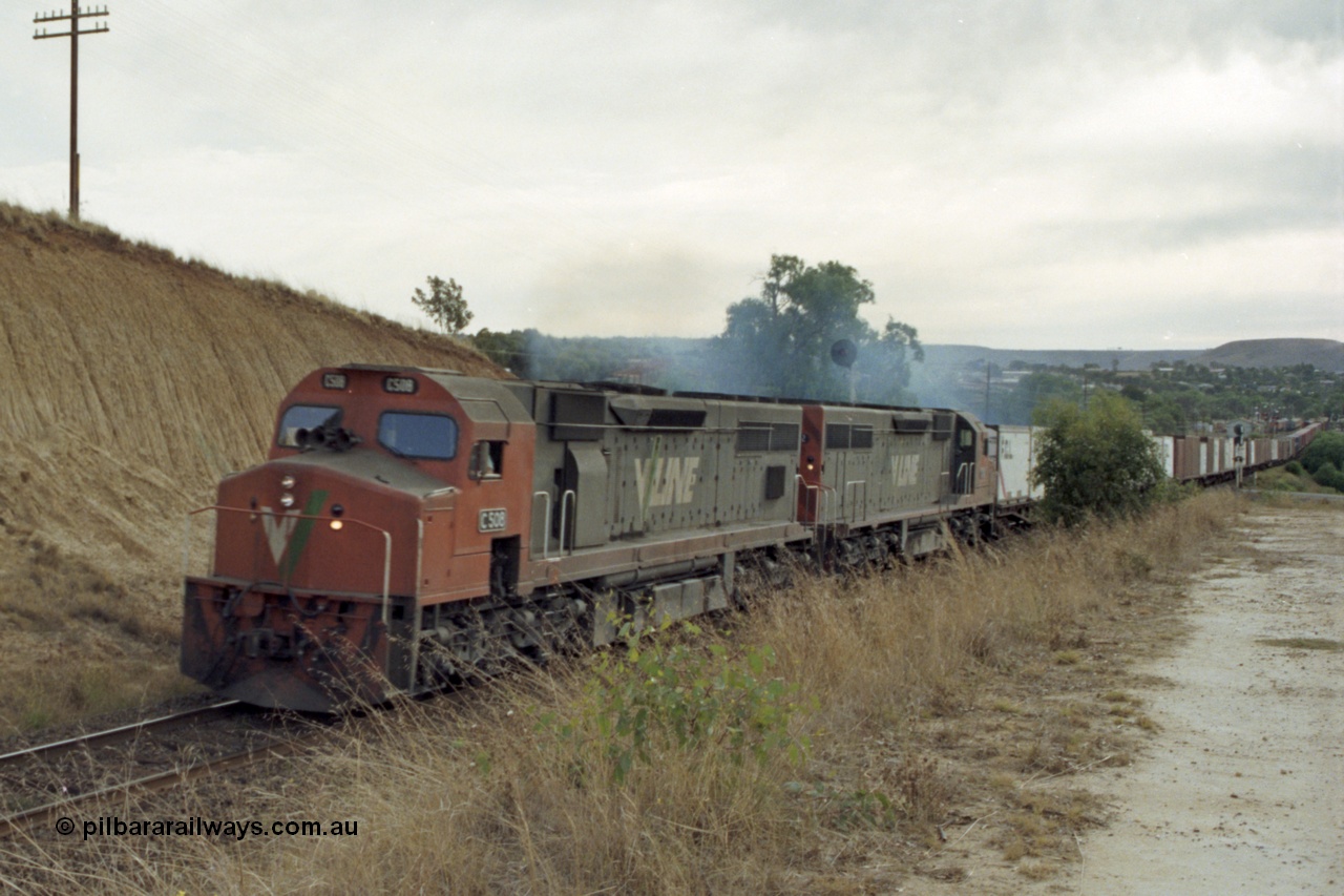 149-25
Bacchus Marsh, V/Line C class locos C 508 Clyde Engineering EMD model GT26C serial 76-831 and C 5?? Power a Melbourne bound 9150? Goods train away from the Marsh at Frisken St, the distant signal can be seen above the trailing C class.
