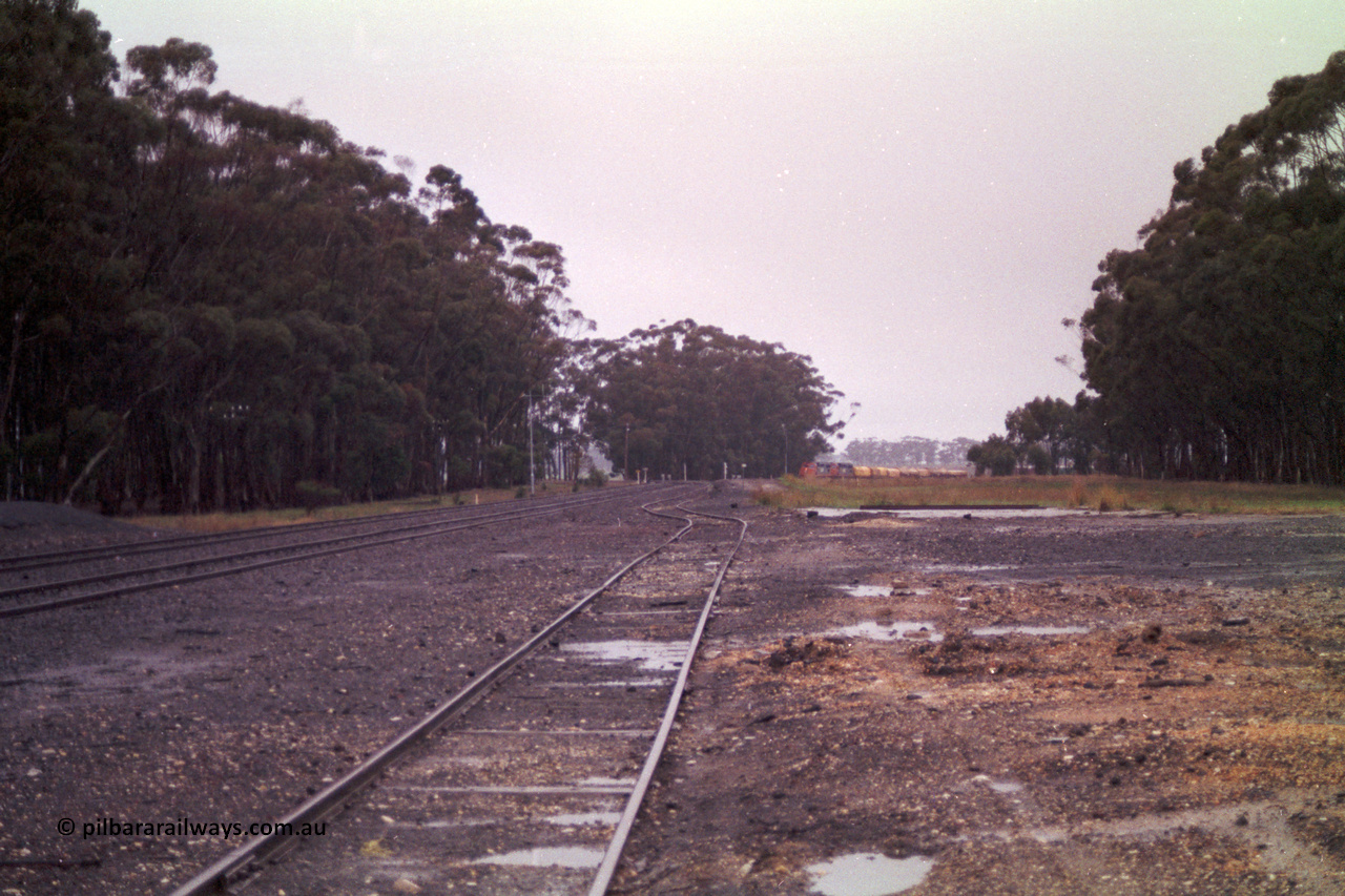 150-13
Lismore, station yard overview looking towards Melbourne from goods loading ramp, V/Line broad gauge C classes Clyde Engineering EMD model GT26C leading Adelaide bound goods train 9169 at the trailable points which are set for left hand lay.
