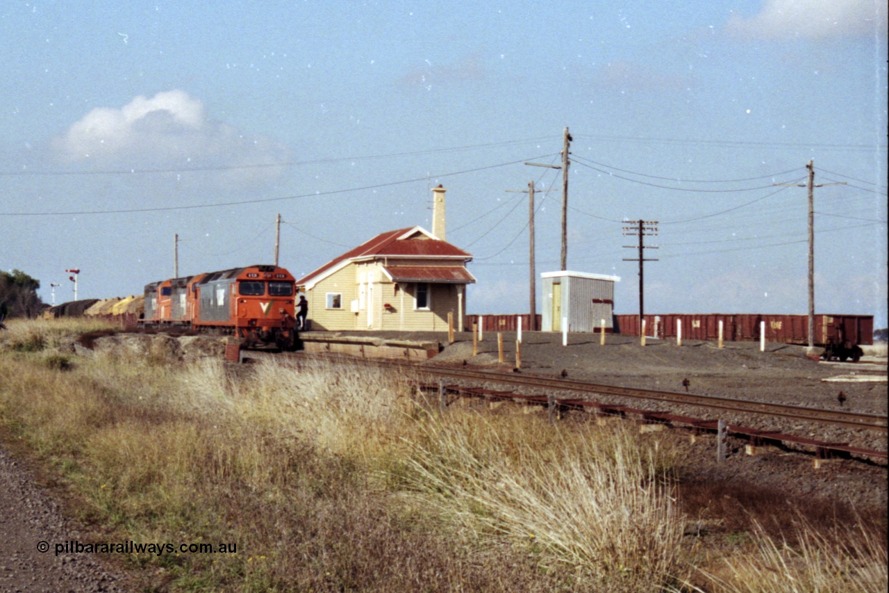 151-15
Gheringhap, broad gauge V/Line Adelaide bound goods train 9169 on No.1 Road under the power of G class G 531 Clyde Engineering EMD model JT26C-2SS serial 88-1261, C class C 510 Clyde Engineering EMD model GT26C serial 76-833 and C 509 serial 76-832, station overview from beyond the former No.2 platform, gypsum waggons in the background, crew boarding having changed electric staff for train order.
Keywords: G-class;G531;Clyde-Engineering-Somerton-Victoria;EMD;JT26C-2SS;88-1261;