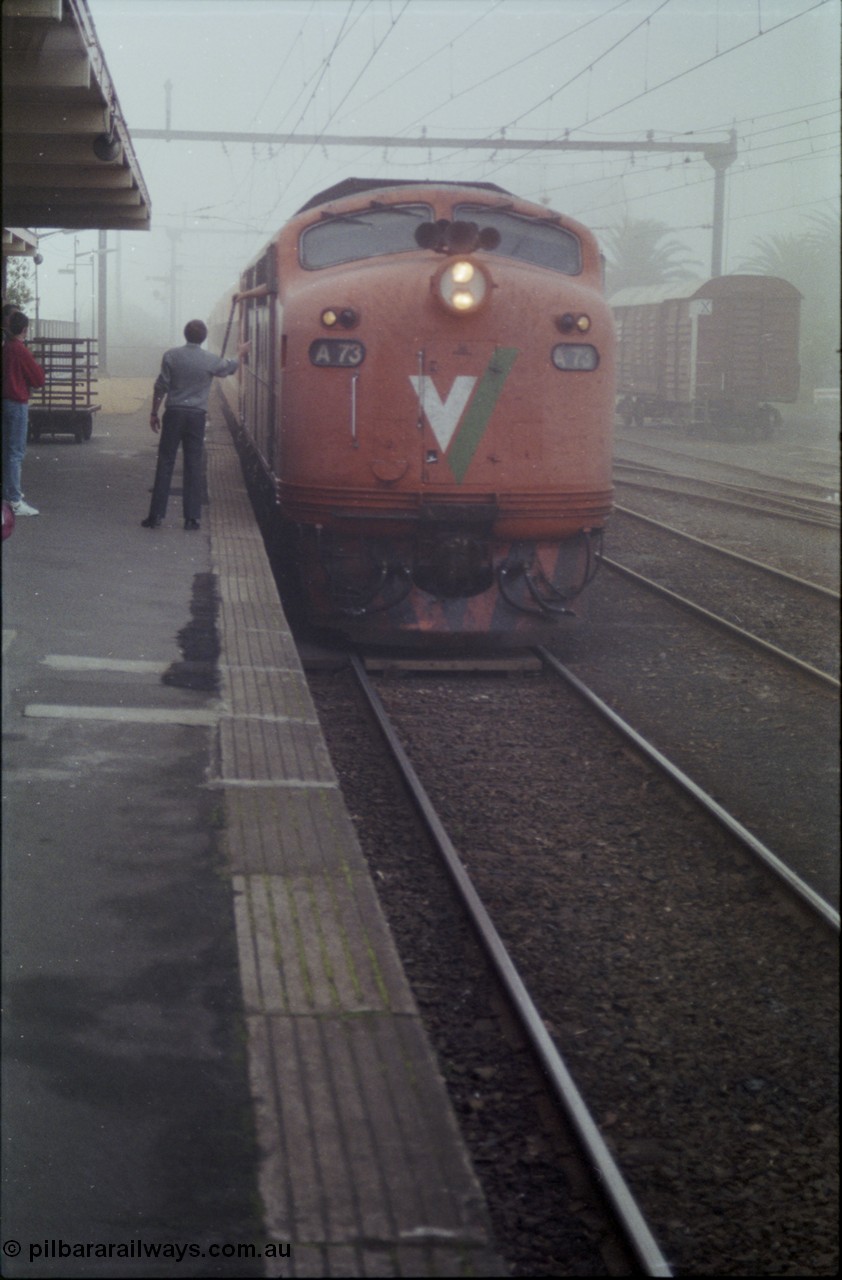 152-04
Morwell station platform, V/Line broad gauge A class A 73 Clyde Engineering EMD model AAT22C-2R serial 83-1179 rebuilt from B 73 Clyde Engineering EMD model ML2 serial ML2-14 with up Traralgon passenger train 8410 surrenders the large electric staff for the Traralgon - Morwell section to the signaller, in heavy fog.
Keywords: A-class;A73;Clyde-Engineering-Rosewater-SA;EMD;AAT22C-2R;83-1179;rebuild;bulldog;
