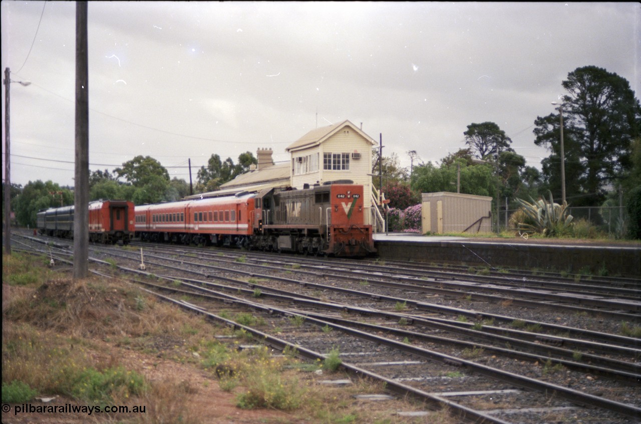 153-1-02
Bacchus Marsh, station yard overview, V/Line broad gauge loco X class X 42 Clyde Engineering EMD model G26C serial 70-705 long end leading and N set with an up passenger service for Melbourne, station platform, elevated signal box, platform shed, stabled pass consist in yard.
Keywords: X-class;X42;Clyde-Engineering-Granville-NSW;EMD;G26C;70-705;