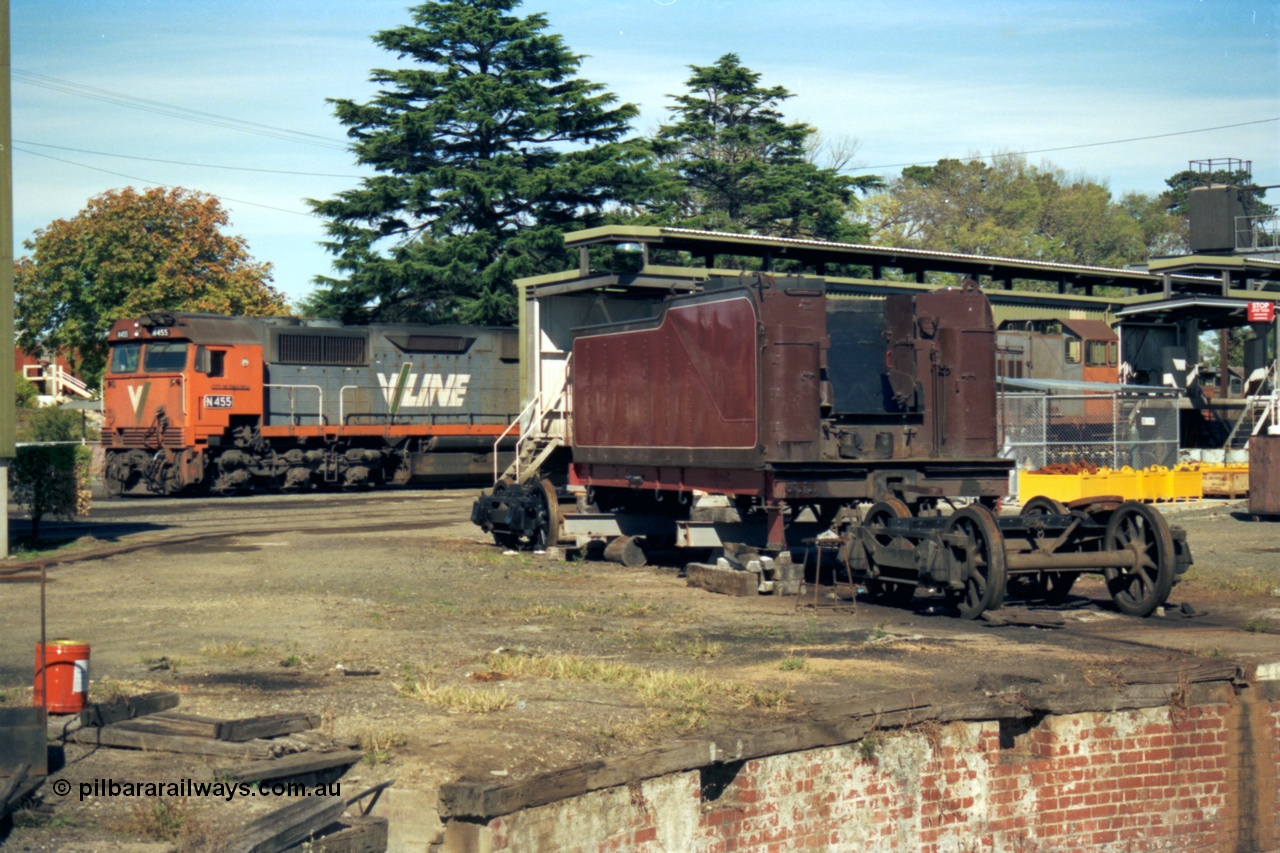 153-2-12
Ballarat East loco depot, turntable pit in bottom corner of frame, D3 class tender under going rebuild, V/Line broad gauge N class N 455 'City of Swan Hill' Clyde Engineering EMD model JT22HC-2 serial 85-1223 next to fuel and sanding sheds, obscured Y class Y 165 Clyde Engineering EMD model G6B serial 68-585.
