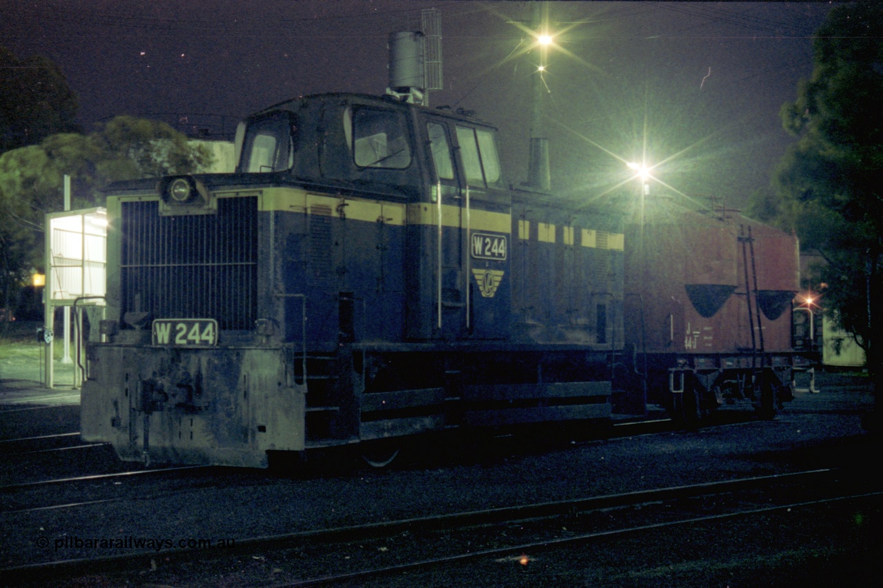 153-3-31
Geelong loco depot, stabled broad gauge Geelong shunt engine W class W 244 Tulloch Ltd model 1-MS 0-6-0 diesel hydraulic serial 9 still in Victorian Railways blue and gold livery, and J type four wheel sand waggon J 44, night shot.
Keywords: W-class;W244;Tulloch-Ltd-NSW;1-MS;9;
