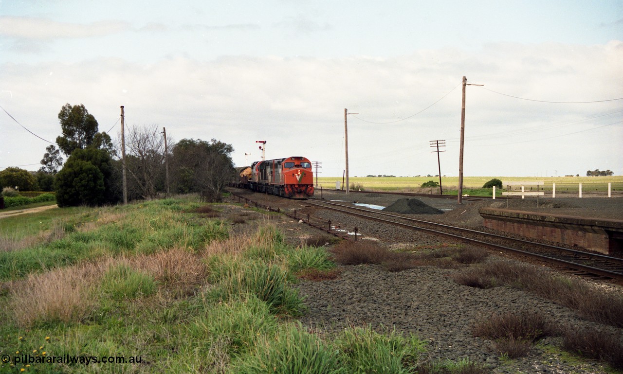 154-01
Gheringhap, V/line broad gauge goods train 9169 to Adelaide, via Cressy arrives, point rodding and station platform, taken from former No.2 platform area, triple C class Clyde Engineering EMD model GT26C on the lead.
Keywords: C-class;C510;Clyde-Engineering-Rosewater-SA;EMD;GT26C;76-833;