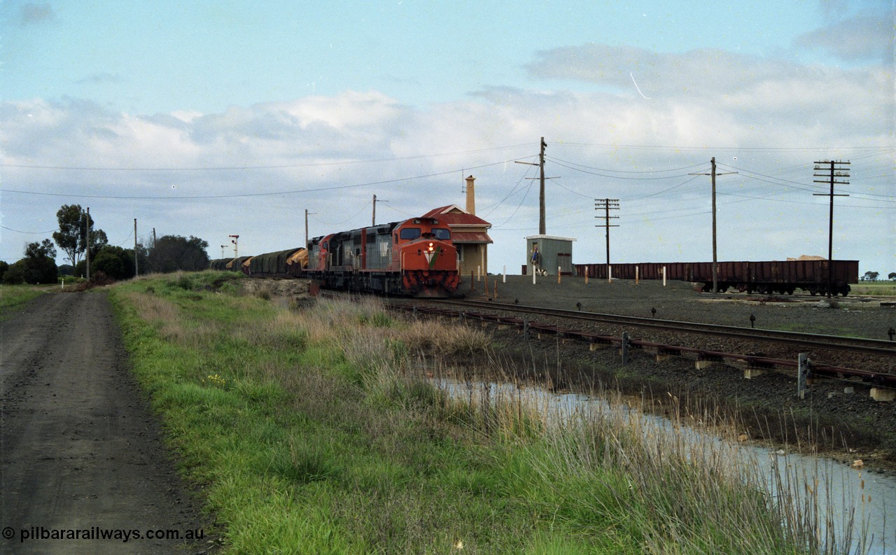 154-05
Gheringhap station yard overview, station building, shed, VOJF type bogie gypsum waggons, V/Line broad gauge goods train 9169 to Adelaide, via Cressy prepares to depart behind triple C class locomotives C 510 Clyde Engineering EMD model GT26C serial 76-833, C 508 serial 76-831 and C class leader C 501 'George Brown' serial 76-824.
Keywords: C-class;C510;Clyde-Engineering-Rosewater-SA;EMD;GT26C;76-833;