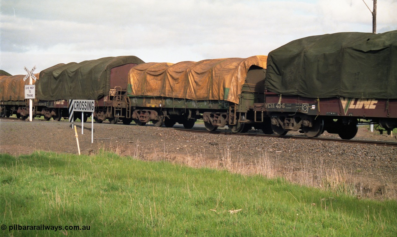 154-13
Lismore, Australian National broad gauge bogie coil steel waggon in the consist of Adelaide bound goods train 9169 crossing Gnarpurt Road sandwich between V/Line VCSX type bogie coil steel waggons VCSX 40 and VCSX 25.
