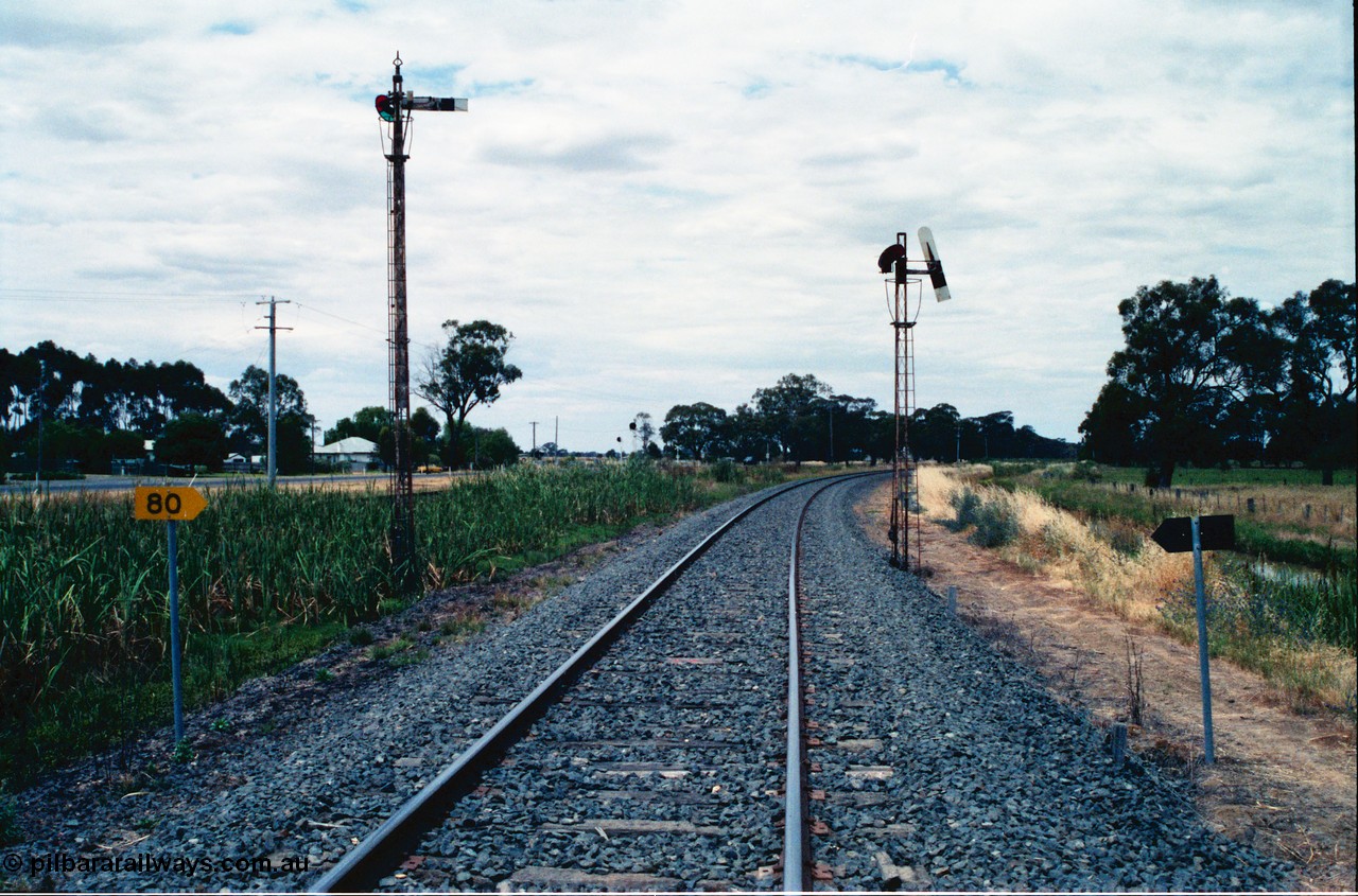 156-25
Numurkah, Picola Junction looking north, up home semaphore signal posts for the Picola line at left and the Strathmerton line on the right, I'm standing on the Strathmerton line and the up home signal is pulled off, 80 km/h speed board.
