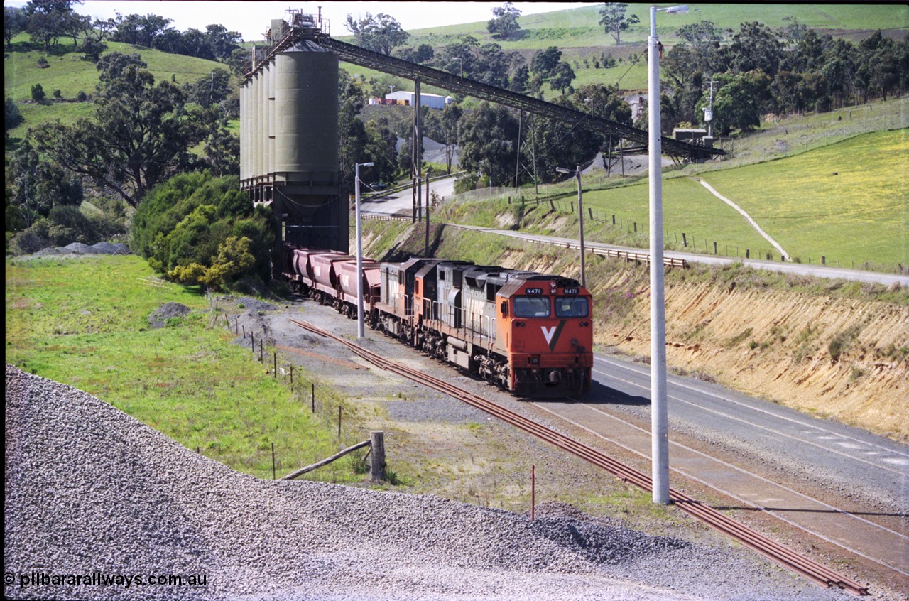 157-18
Kilmore East, Apex Quarry Siding, V/Line broad gauge locomotives N class N 471 'City of Benalla' Clyde Engineering EMD model JT22HC-2 serial 87-1200 and T class T 390 Clyde Engineering EMD model G8B serial 65-420 and type class bogie quarry products waggons pushing back under the loading bins, view taken from on top of ballast pile.
Keywords: N-class;N471;Clyde-Engineering-Somerton-Victoria;EMD;JT22HC-2;87-1200;