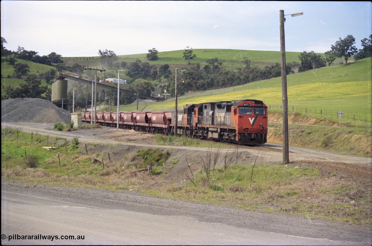 157-27
Kilmore East, Apex Quarry Siding, V/Line broad gauge locomotives N class N 471 'City of Benalla' Clyde Engineering EMD model JT22HC-2 serial 87-1200 and T class T 390 Clyde Engineering EMD model G8B serial 65-420 with train under the loading bins during loading operations, view across Broadford - Kilmore Road.
Keywords: N-class;N471;Clyde-Engineering-Somerton-Victoria;EMD;JT22HC-2;87-1200;