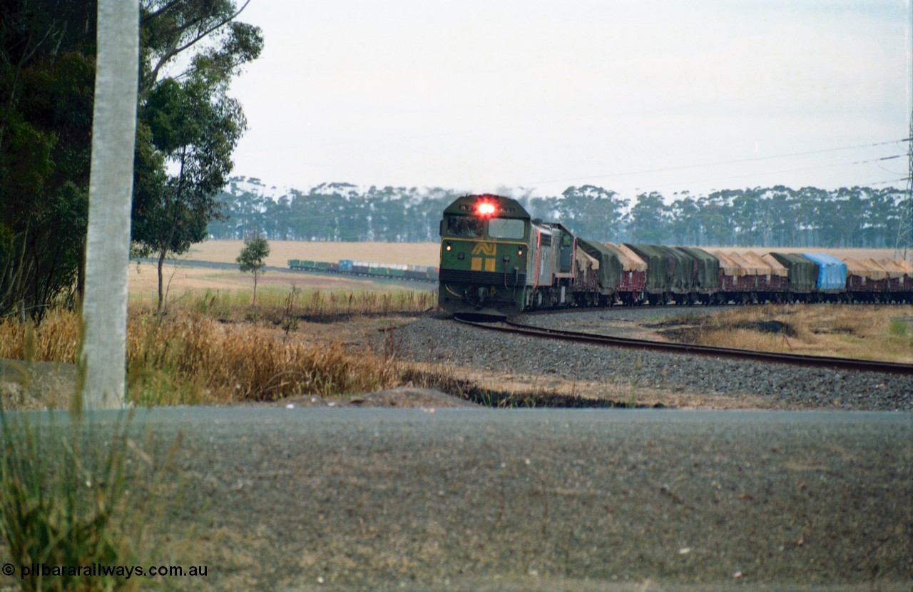 159-14
Lismore, distant view across Gnarpurt Road grade crossing of Australian National broad gauge BL class BL 27 Clyde Engineering EMD model JT26C-2SS serial 83-1011 leading a sister BL class and V/Line S and X class locomotives with down goods train 9169 as it runs round the curves on their way to Adelaide.
Keywords: BL-class;BL27;Clyde-Engineering-Rosewater-SA;EMD;JT26C-2SS;83-1011;