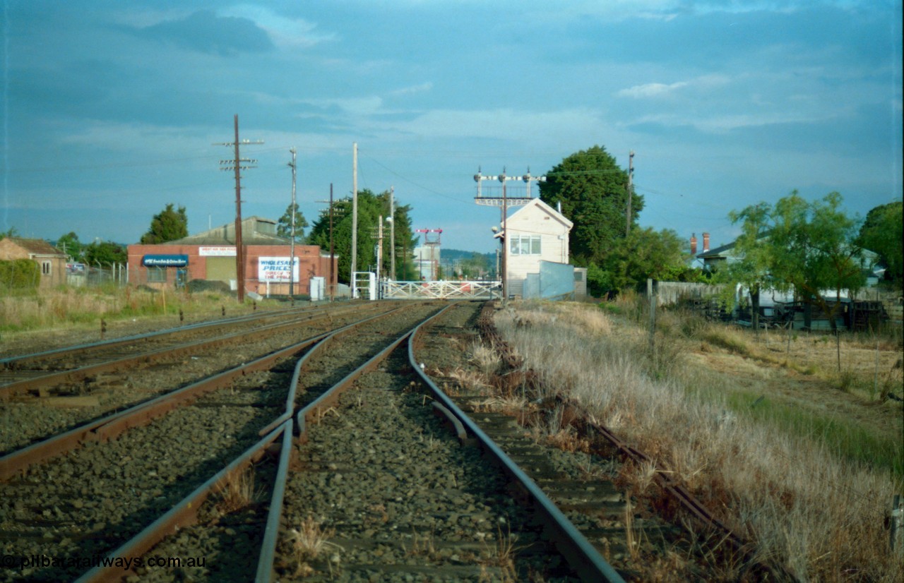 159-16
Ballarat D Signal Box, Linton Junction, broad gauge track view from the Cattle Yard Line looking east, Linton Line then the Ararat Line with the down crossover visible, triple doll semaphore signal 20 facing down train is visible behind the signal box, with the Gillies Street interlocked gates, staff exchange platform and up home semaphore signal post 19, points, track work and point rodding.

