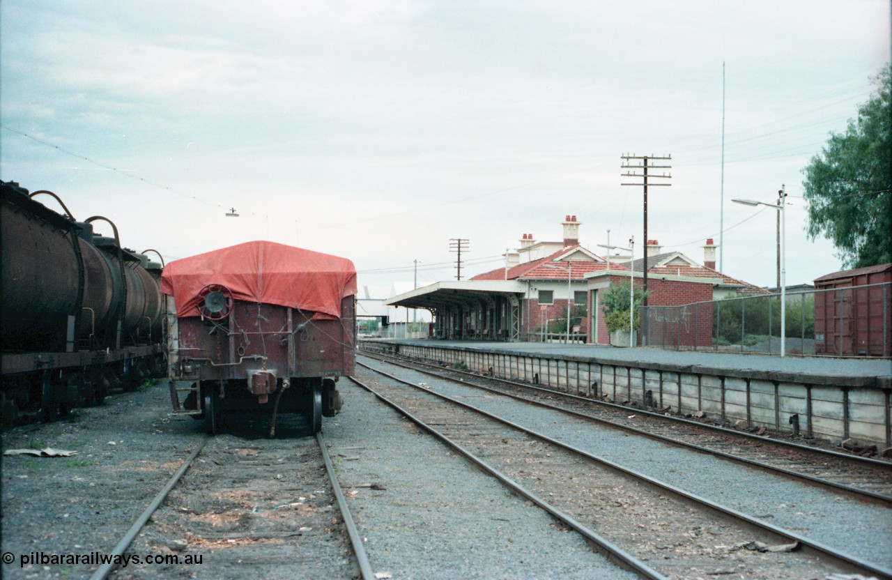 160-20
Shepparton yard view, stabled fuel train on No.4 Rd at left, hand brake end of super phosphate waggon, rear of stabled Shepparton goods train on No.3 Rd, station building and platform on the right.
