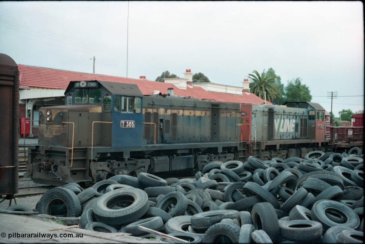 160-24
Shepparton, stabled V/Line broad gauge T class locomotives T 385 Clyde Engineering EMD model G8B serial 64-340 still in Victorian Railways blue and yellow livery and T 393 serial 65-423 off the down Shepparton fuel train, looking from the good loading platform with a mountain of 2nd hand tyres piled up.
Keywords: T-class;T385;Clyde-Engineering-Granville-NSW;EMD;G8B;64-340;