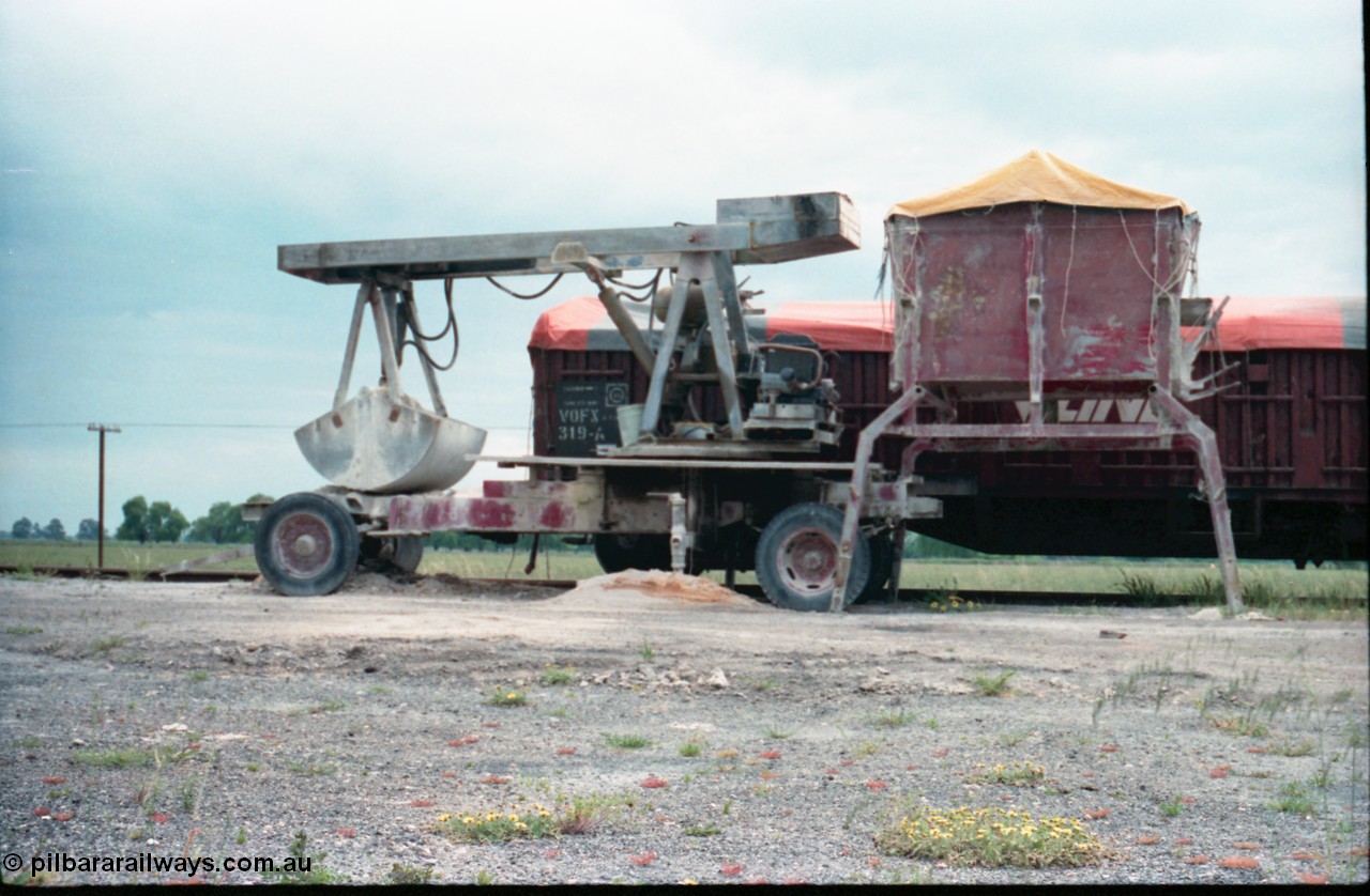 161-09
Katunga, super phosphate unloading contraption, truck hopper on legs and V/Line VOFX type bogie open waggon VOFX 319 covered with tarpaulin, built by Victorian Railways Bendigo Workshops in November 1970 as an ELX type, in 1979 to VOBX, in 1981 to VOCX and in 1987 to VOFX.
Keywords: VOFX-type;VOFX319;Victorian-Railways-Bendigo-WS;ELX-type;