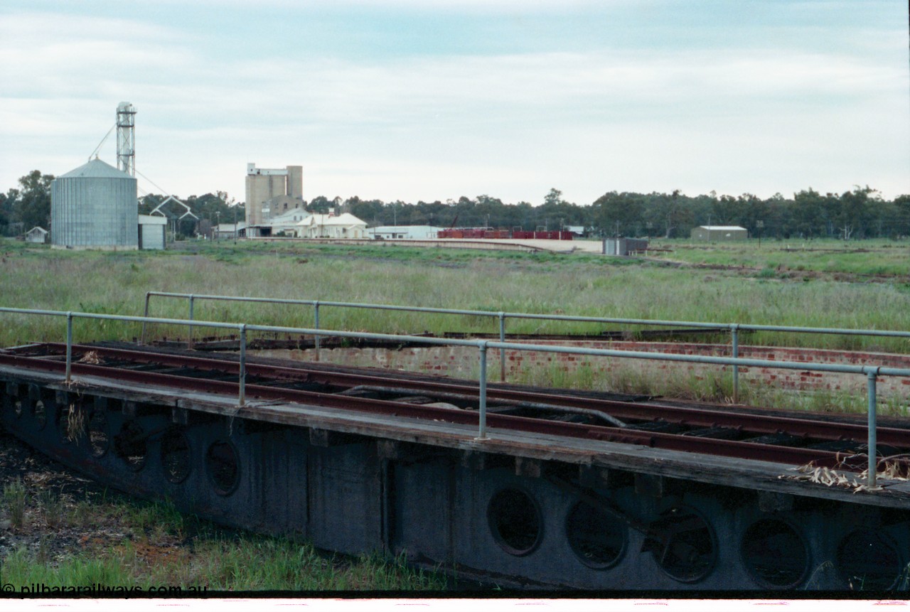 161-32
Tocumwal, overview of the overgrown standard gauge NSWGR yards taken looking south from turntable and pit, silos on the left, derelict flour mill, station building and platform and V/Line broad gauge sleeper transport waggons, standard gauge fettlers shed is at this end of platform.
