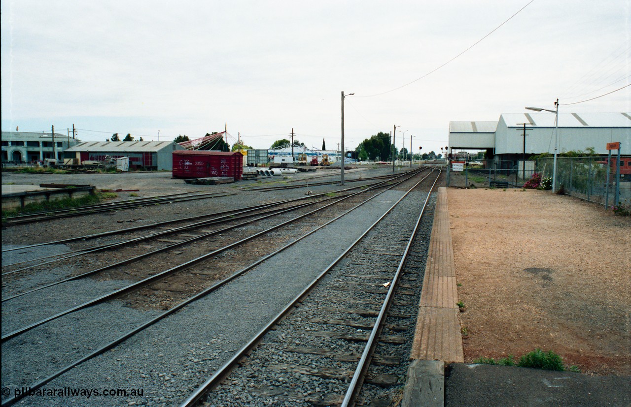 163-25
Shepparton station yard overview looking north from platform, the platform road is the line to Katamatite, with No.2 Road the line to Tocumwal, loading platform just visible and grounded B van.
