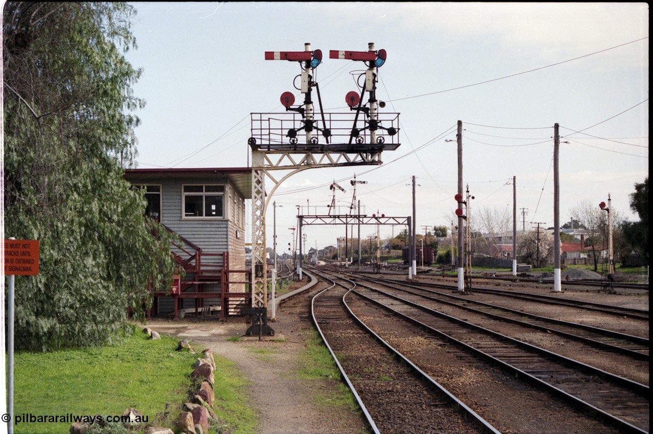 165-00
Wodonga, yard overview looking south from station platform past signal box A, steel lattice double doll semaphore signal post 19, semaphore signal 10B pulled off for down passenger train, semaphore signal post 10, double disc signal posts 12 and 17 with disc signal post 16 on the right, the louvre vans in the background are on the former coal stage track.

